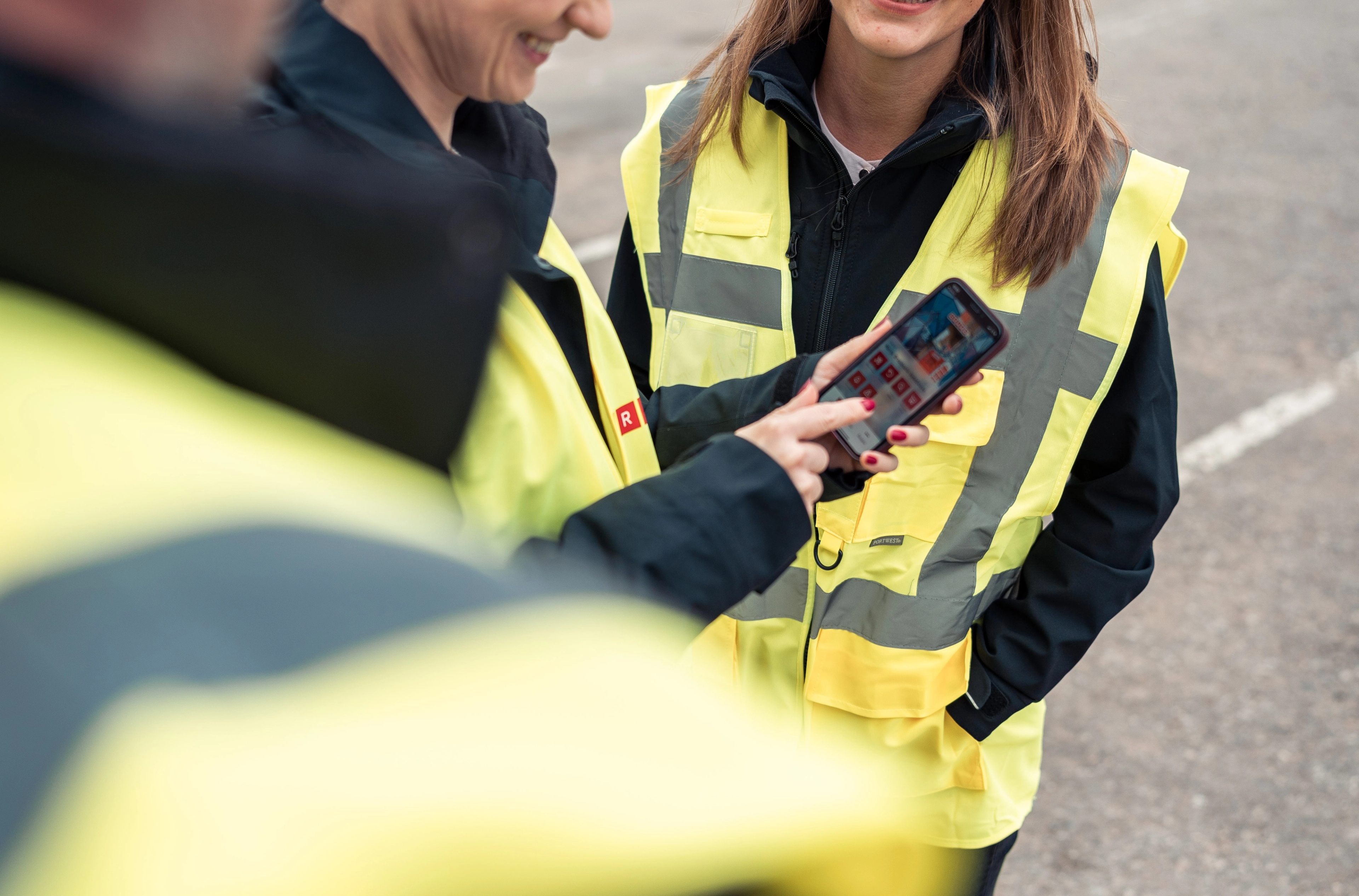 Three persons looking at a cell phone