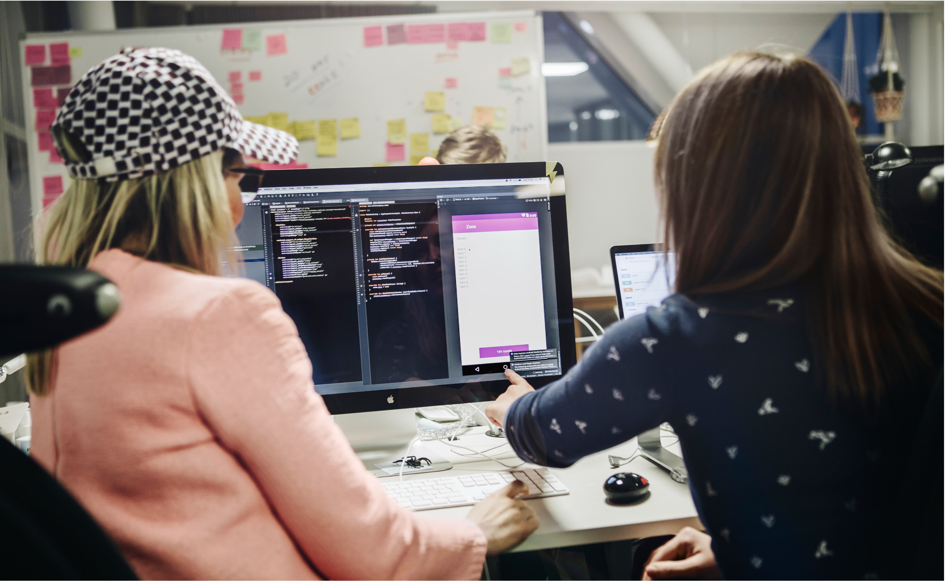 Två kvinnor sitter framför en datorskärm och arbetar med UX.