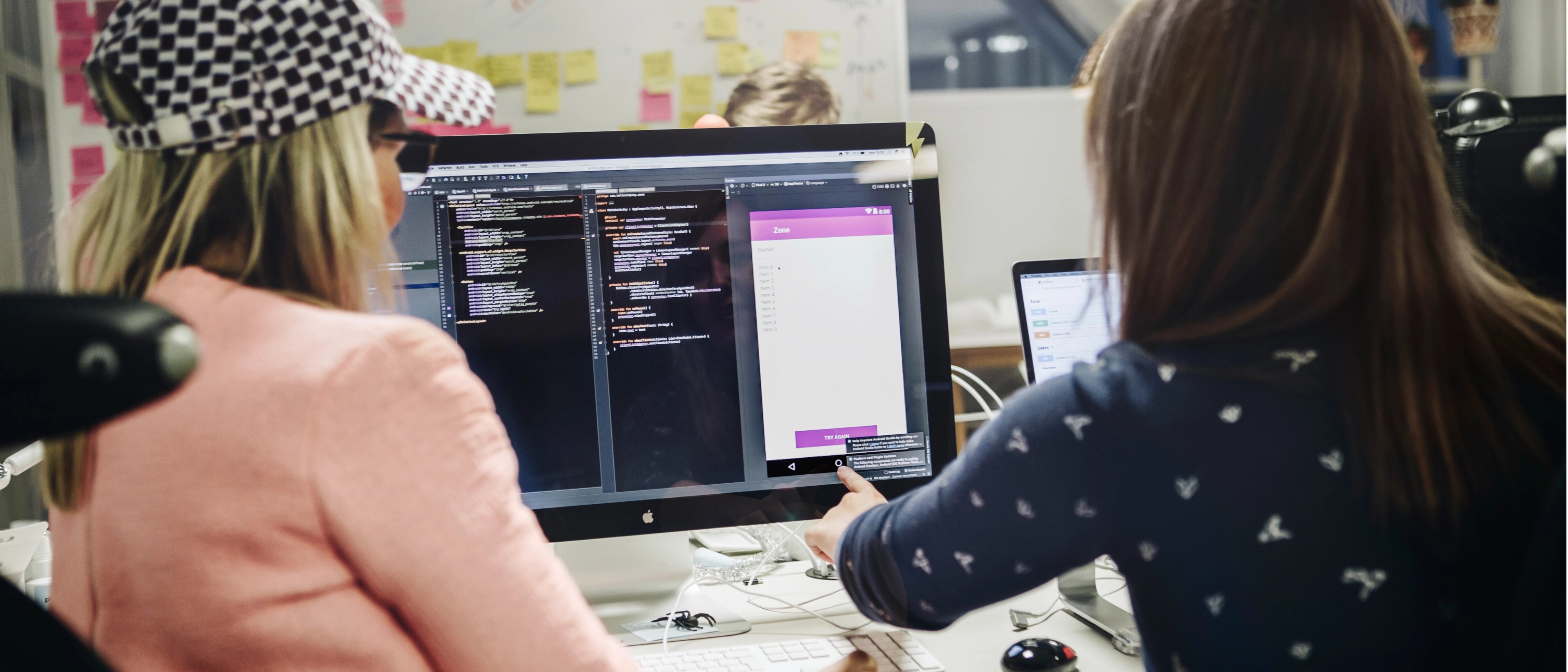 Två kvinnor sitter framför en datorskärm och arbetar med UX.
