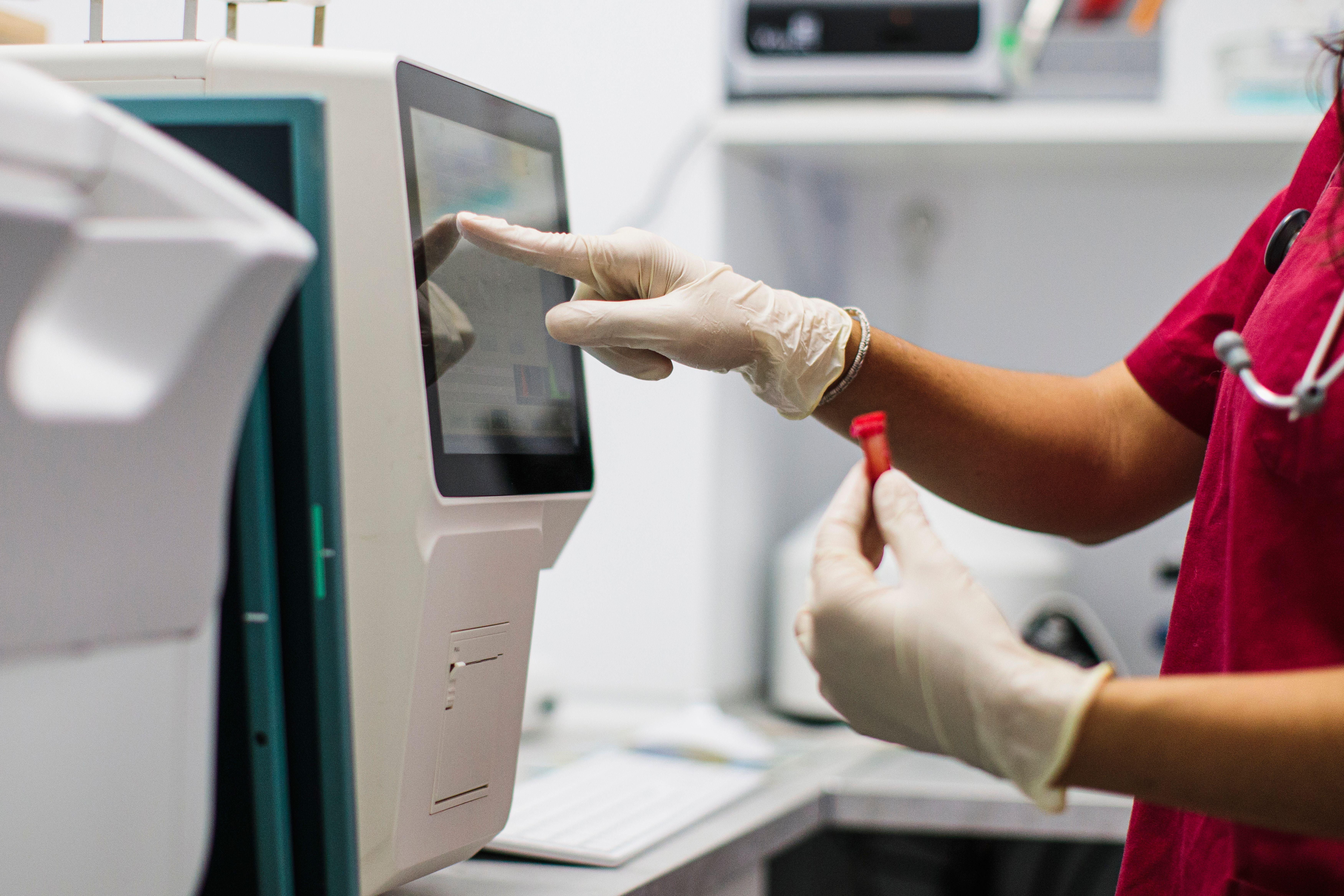 A closeup of a lab table with tests and a hand with a glove
