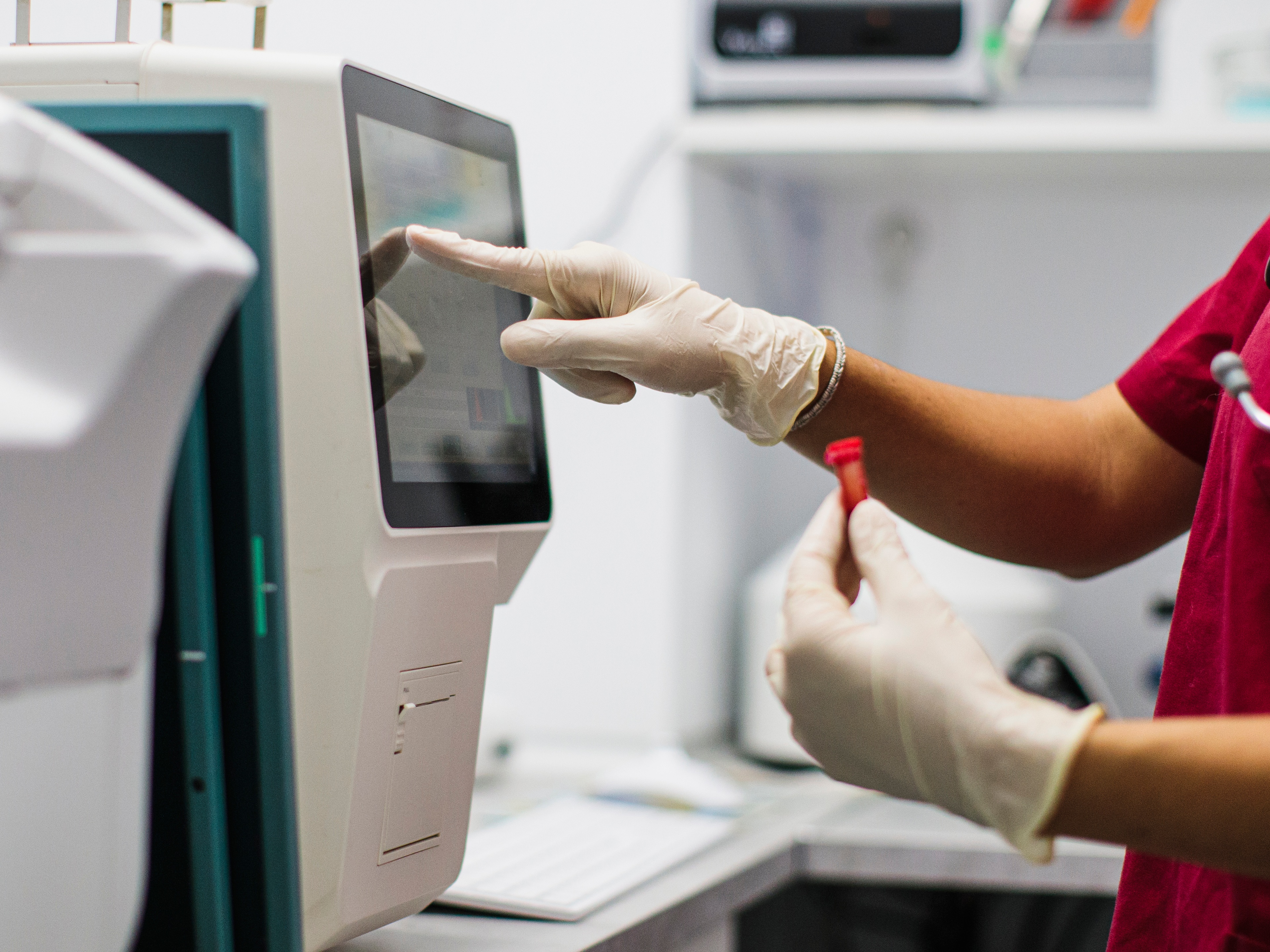 A closeup of a lab table with tests and a hand with a glove