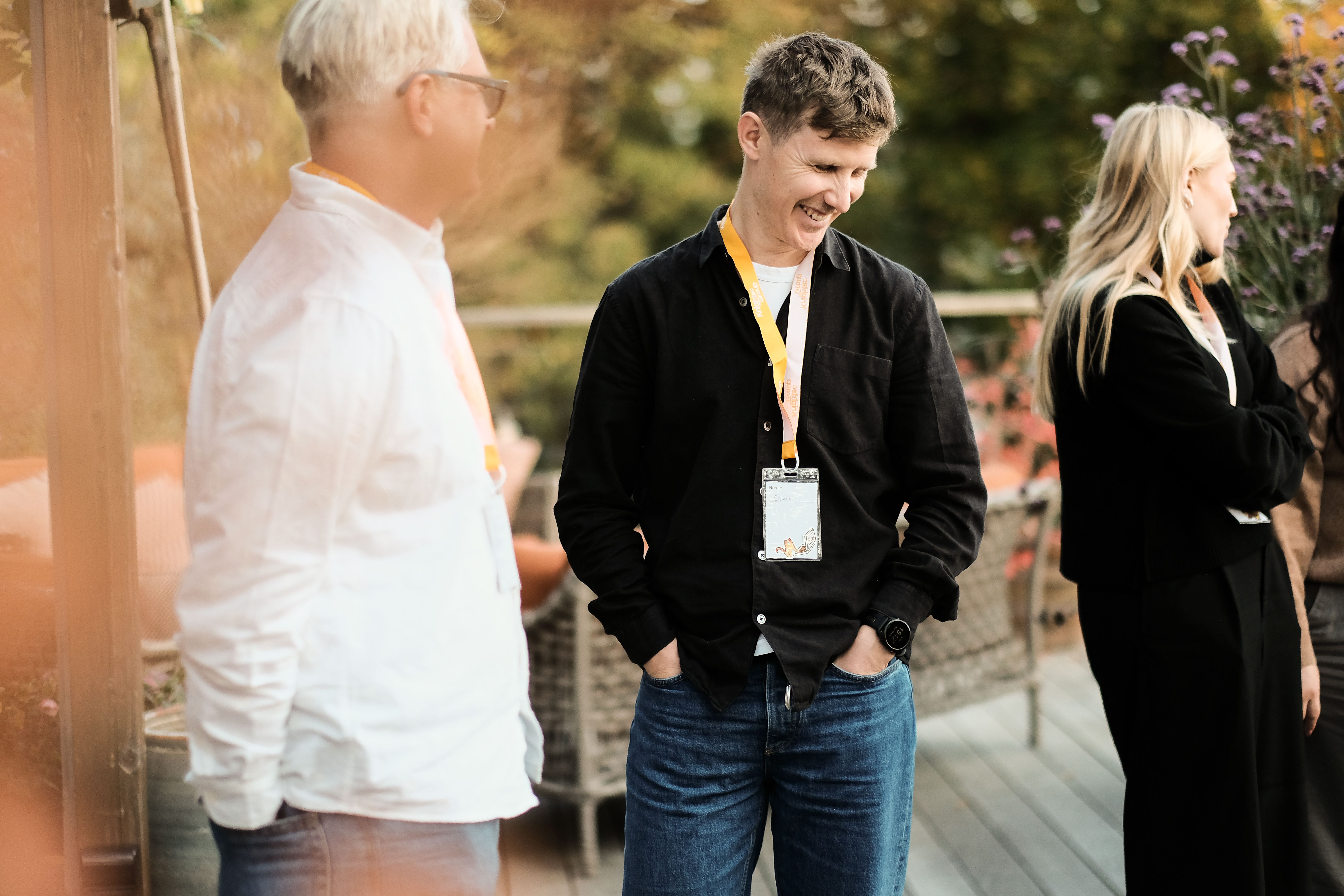Three people standing in an outside setting at an event