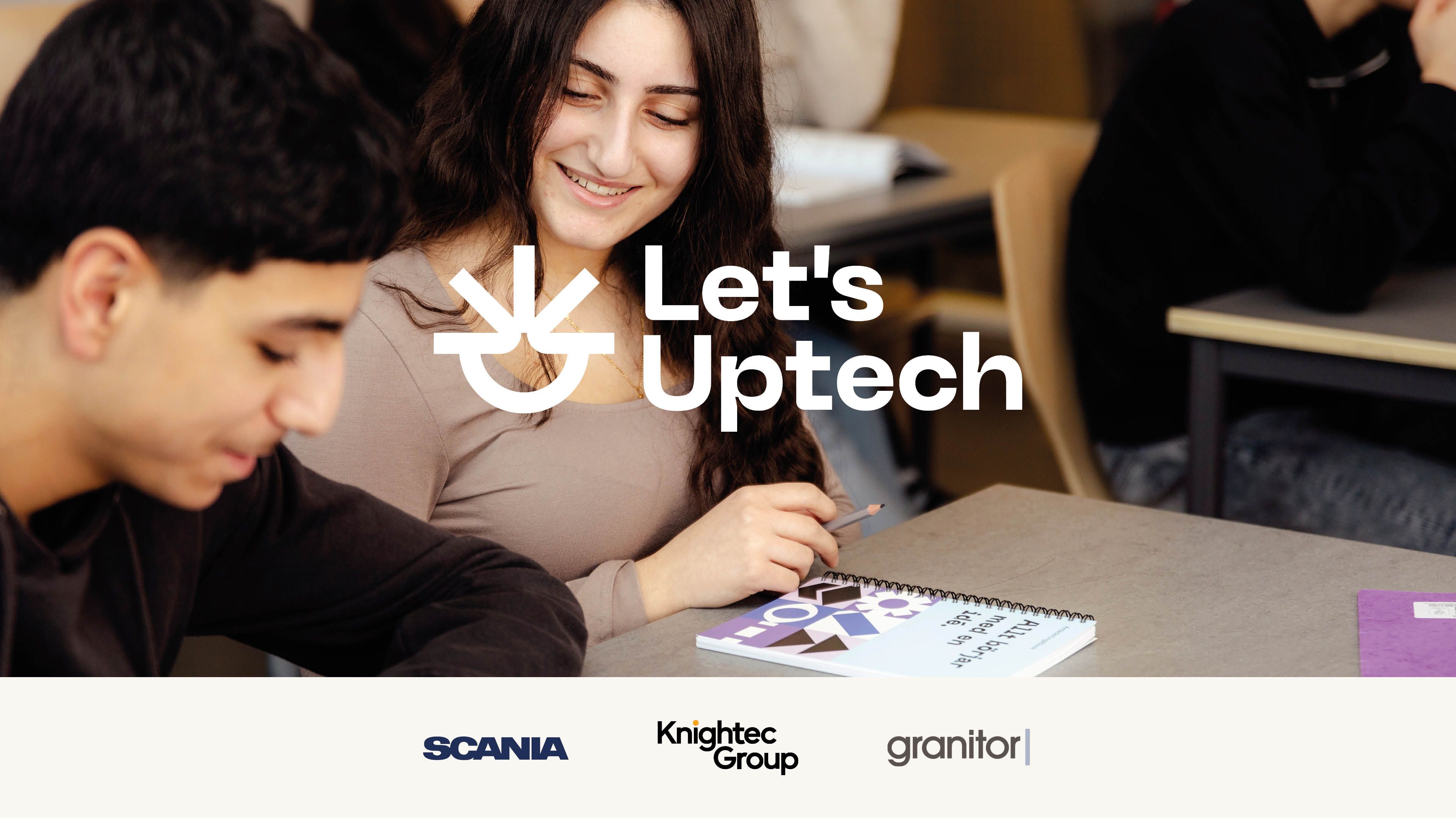 Two students sitting at a desk, the text Let's Uptech written across the image