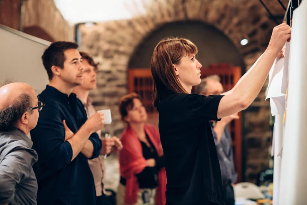 Image of a woman attaching a piece of paper on the wall