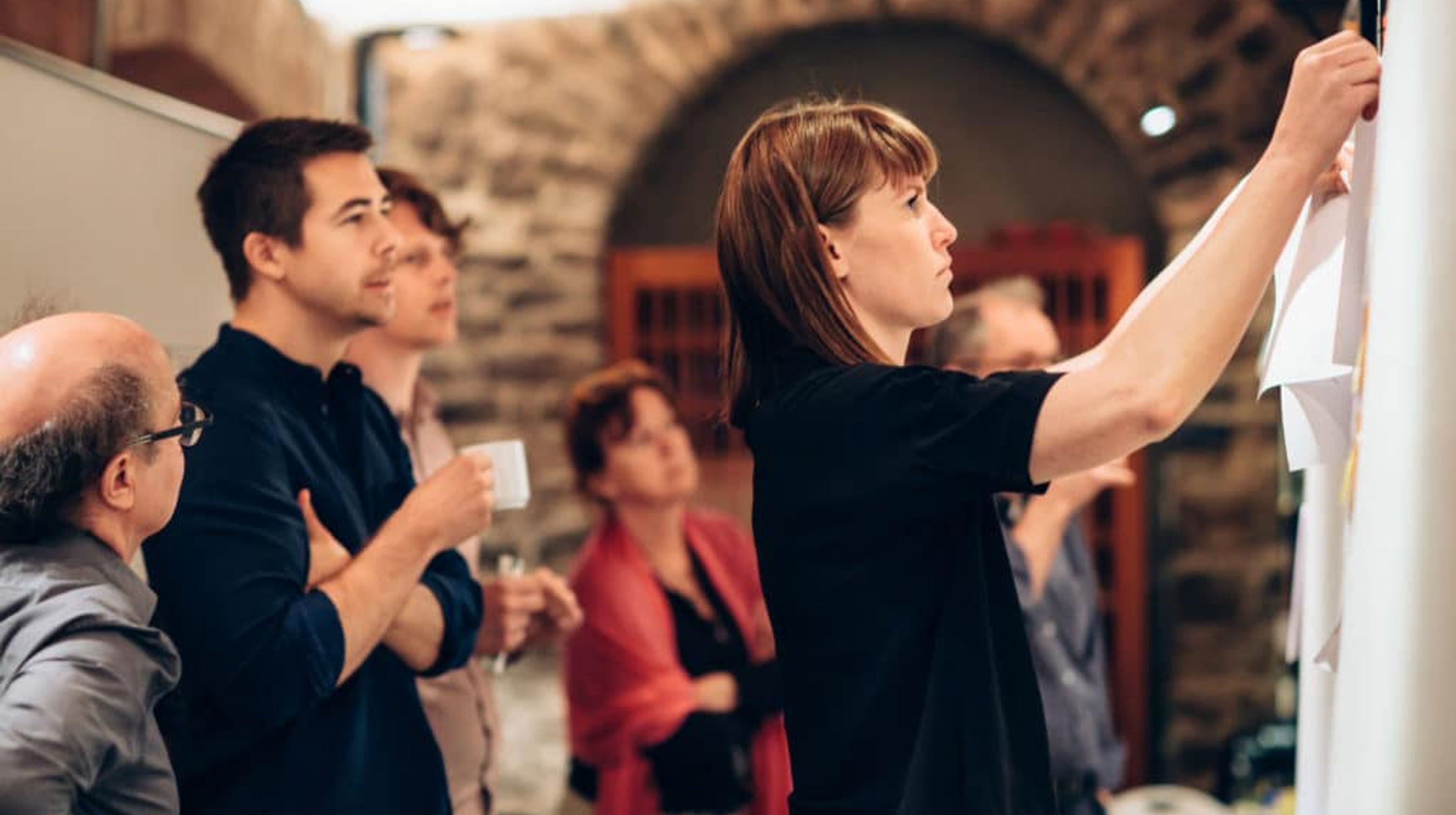 A group of people hanging information on a bulletin board