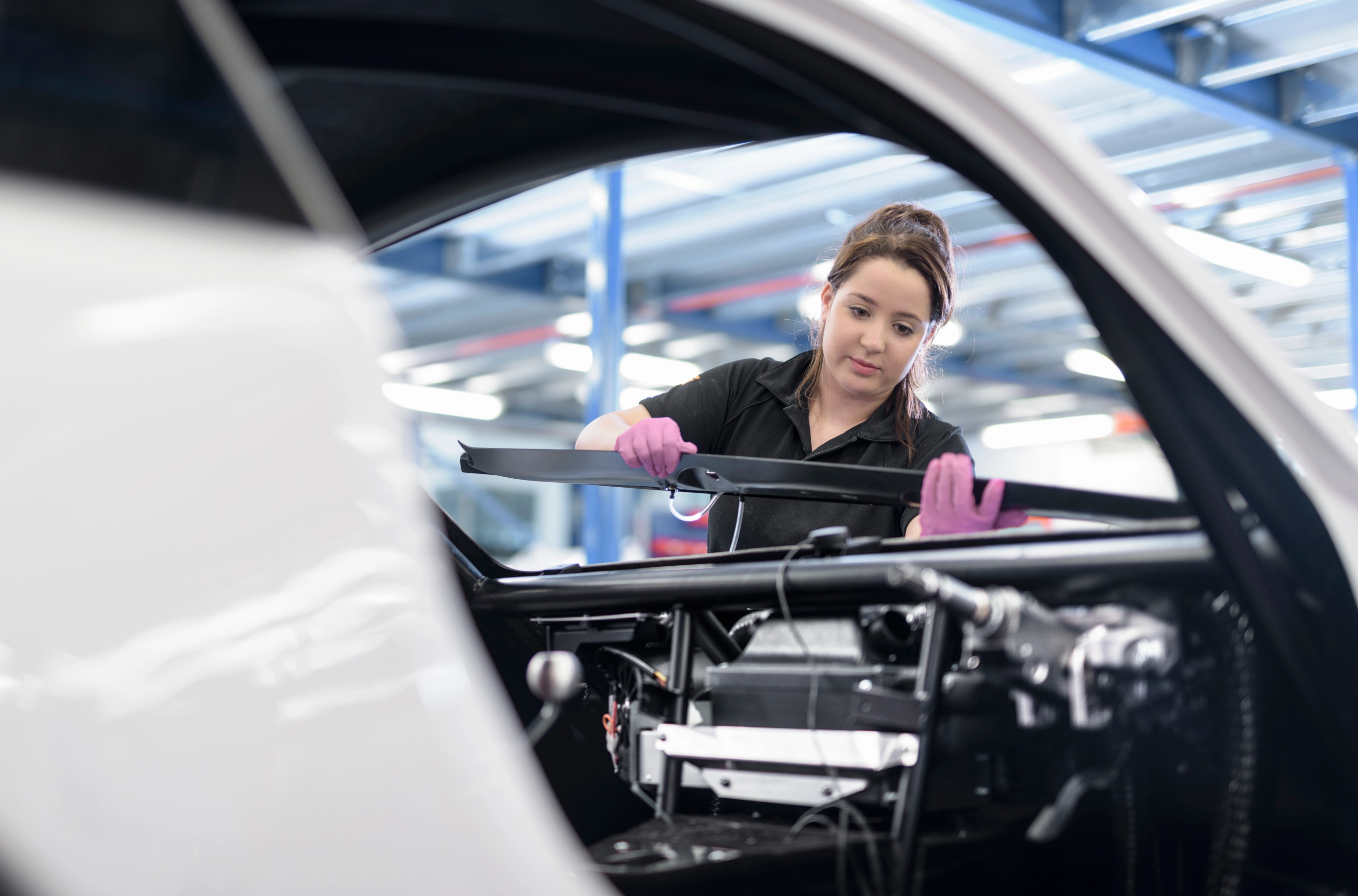 Uma mulher trabalhando em uma linha de produção de carros