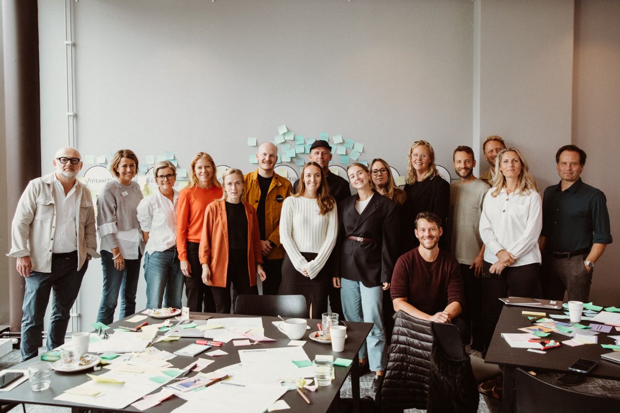 Grupp människor står framför en vägg och poserar mot kameran.