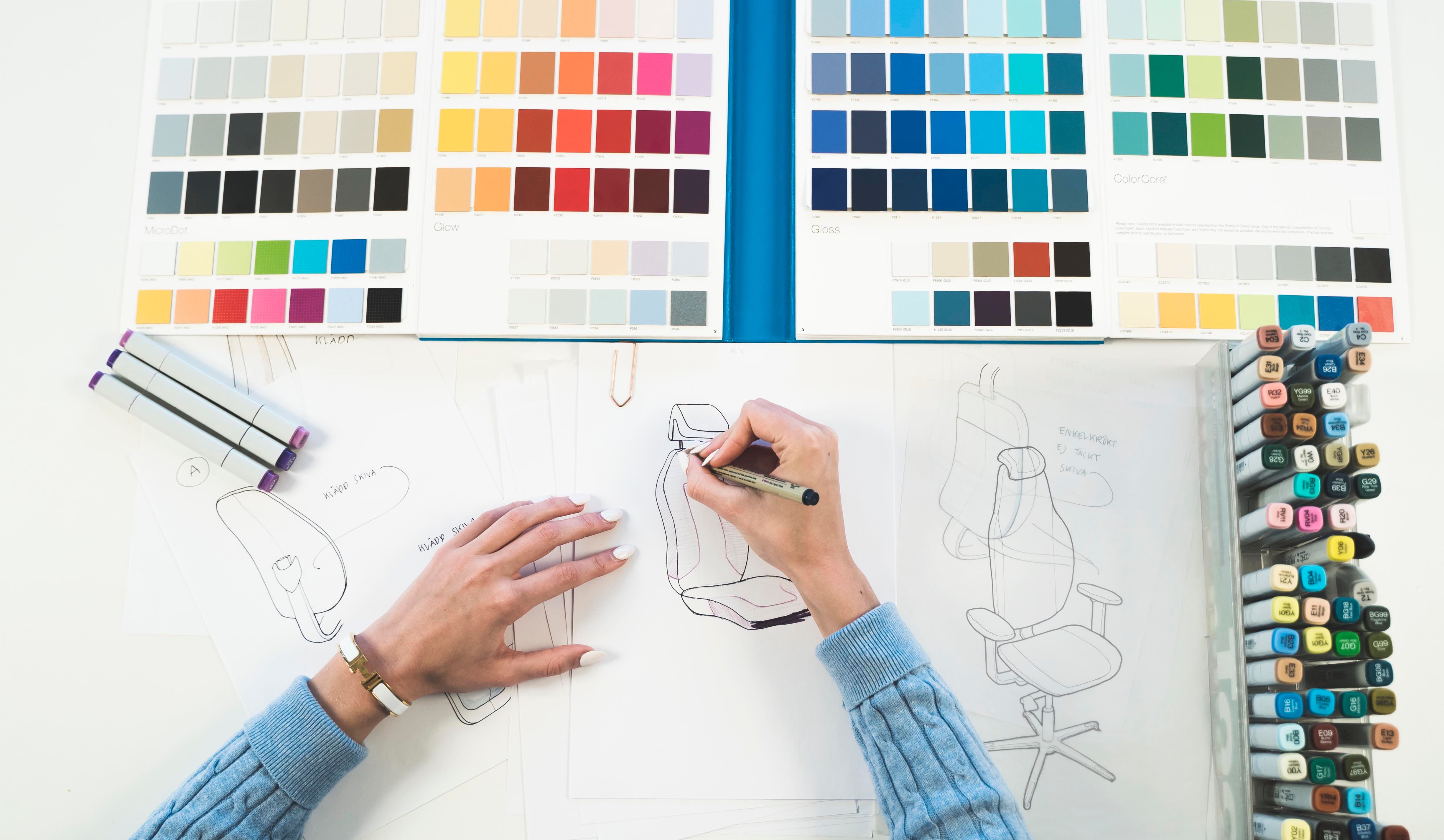 Two hands working on a design drawing