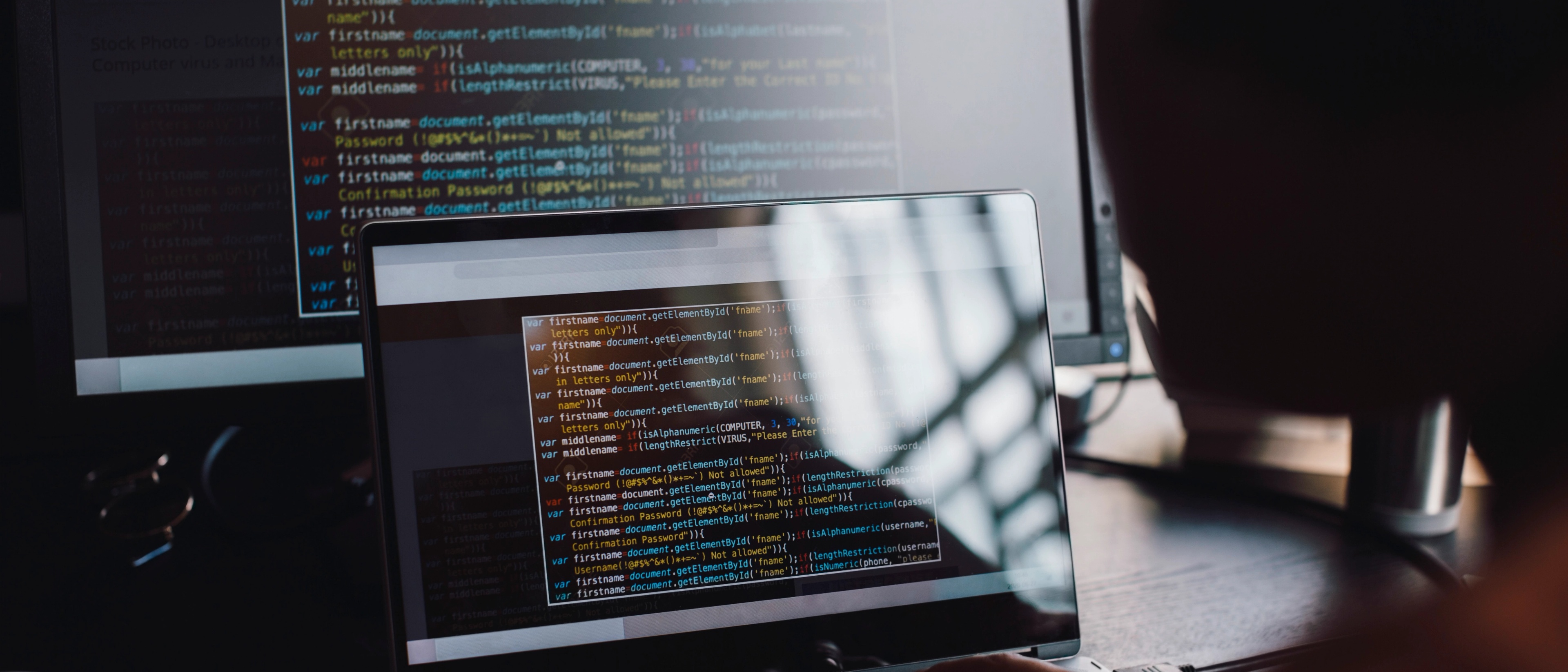 Code in front of two computer screens