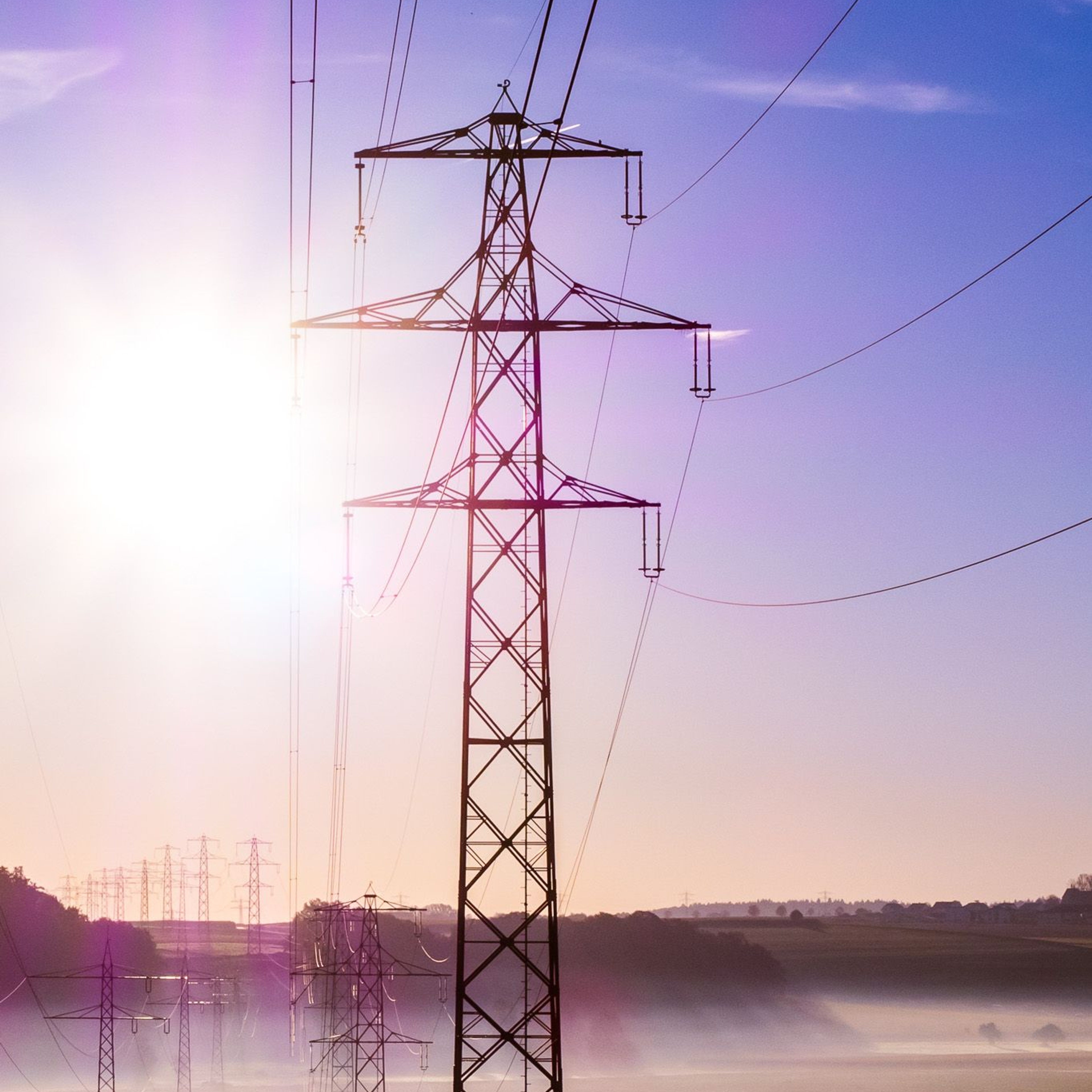 Power line towards a blue sunny sky with low dim banks