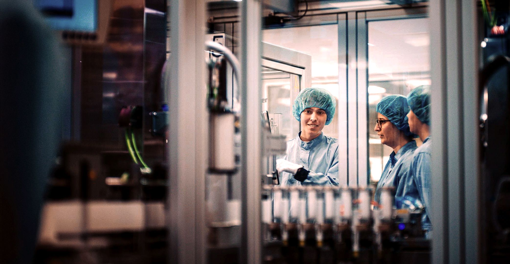 A group of people wearing safety clothing in a laboratory