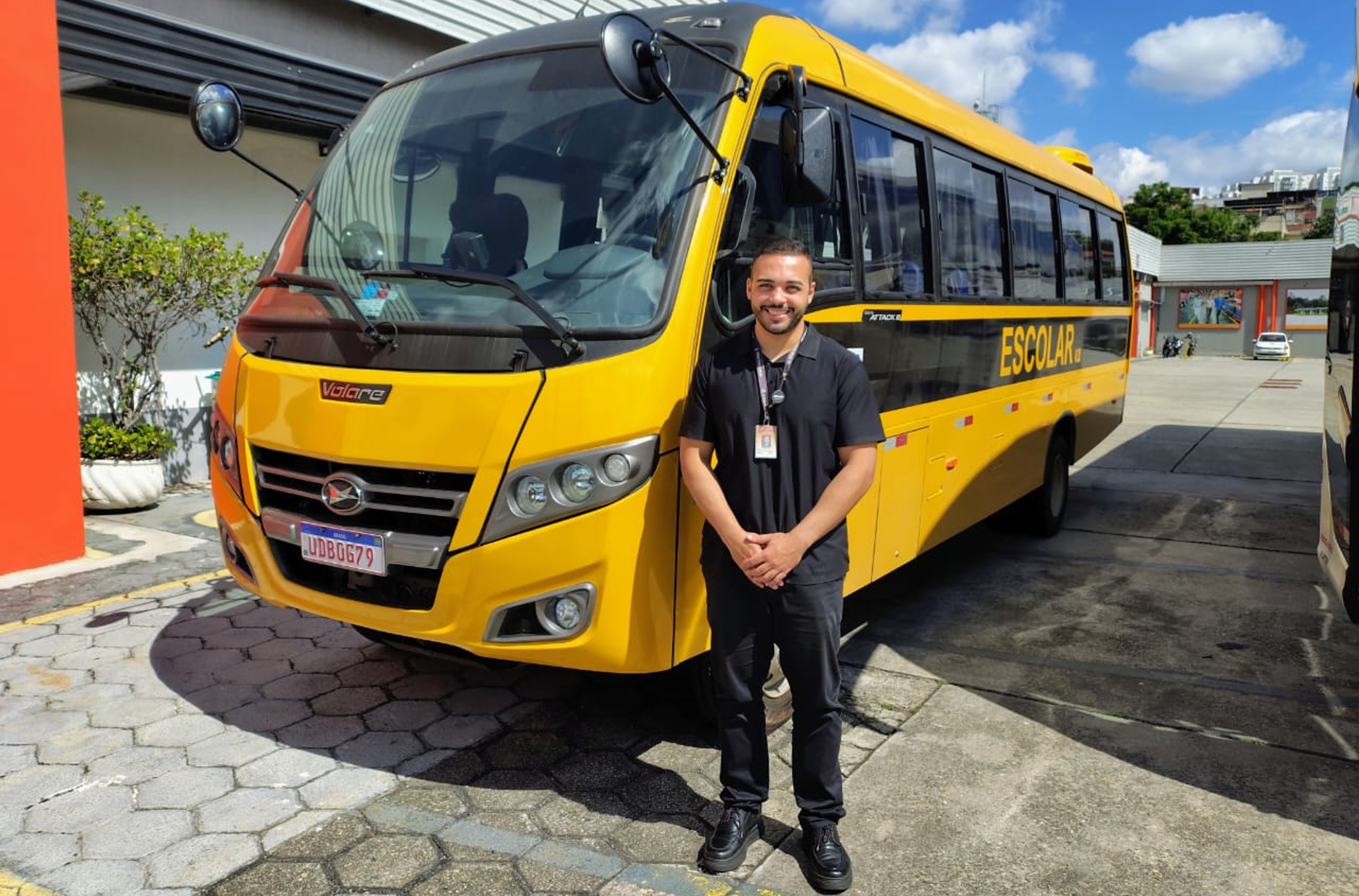 Um homem em pé na frente de um ônibus.