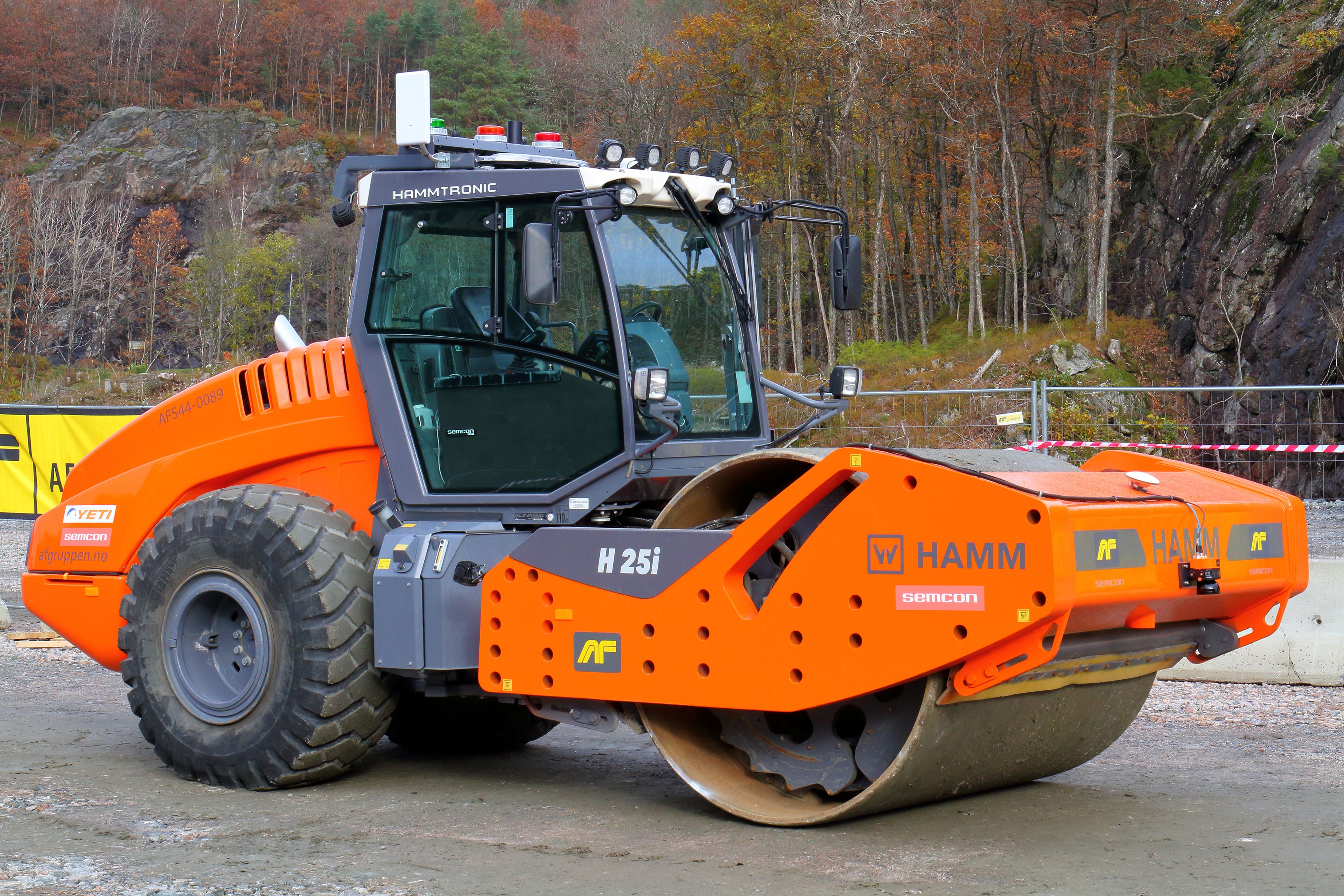 Road roller machine compacting ground at a construction site.