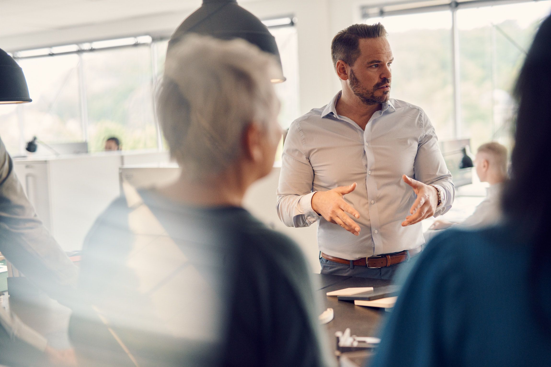 A group of people standing around a table discussing