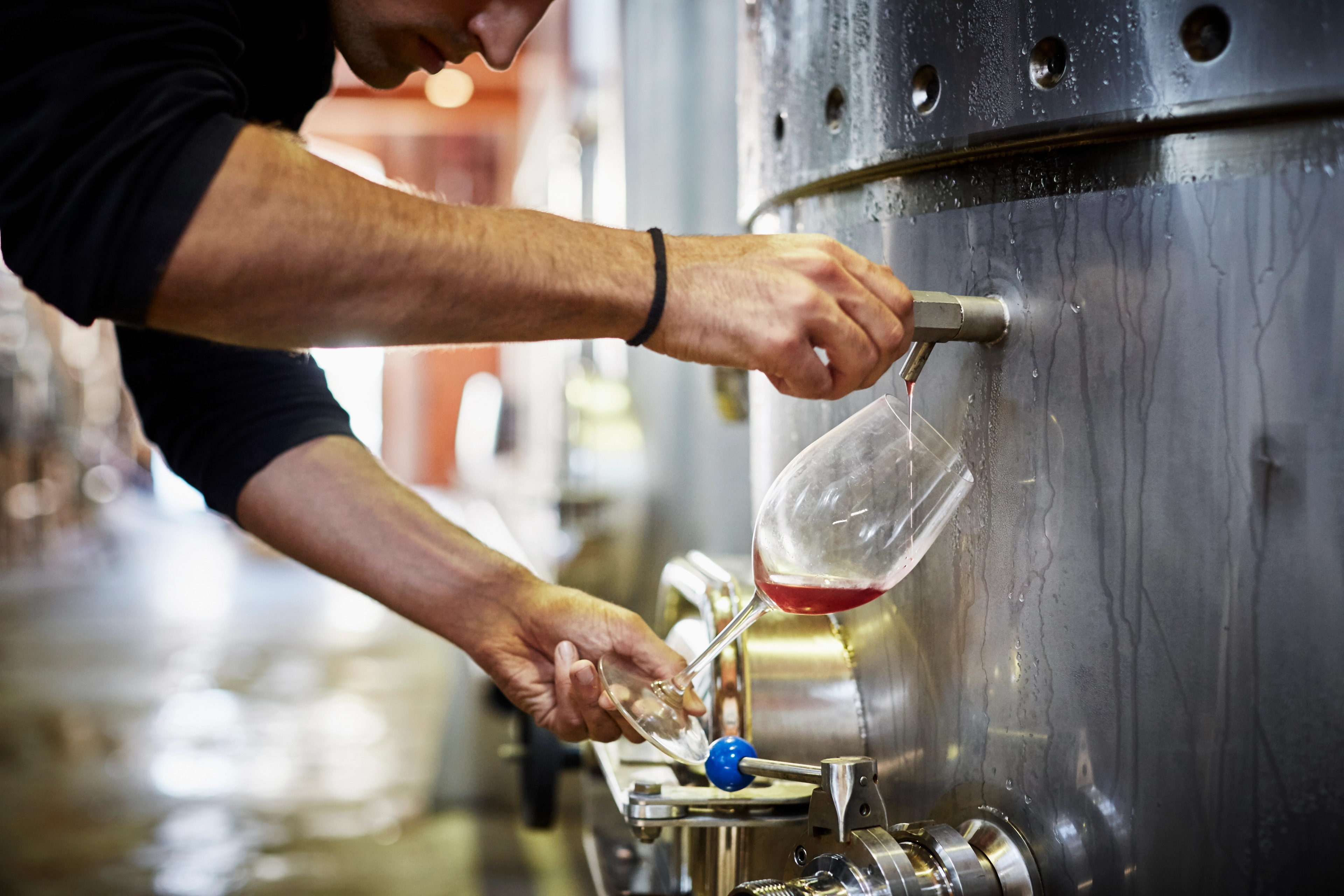 A man filling up a glass of wine