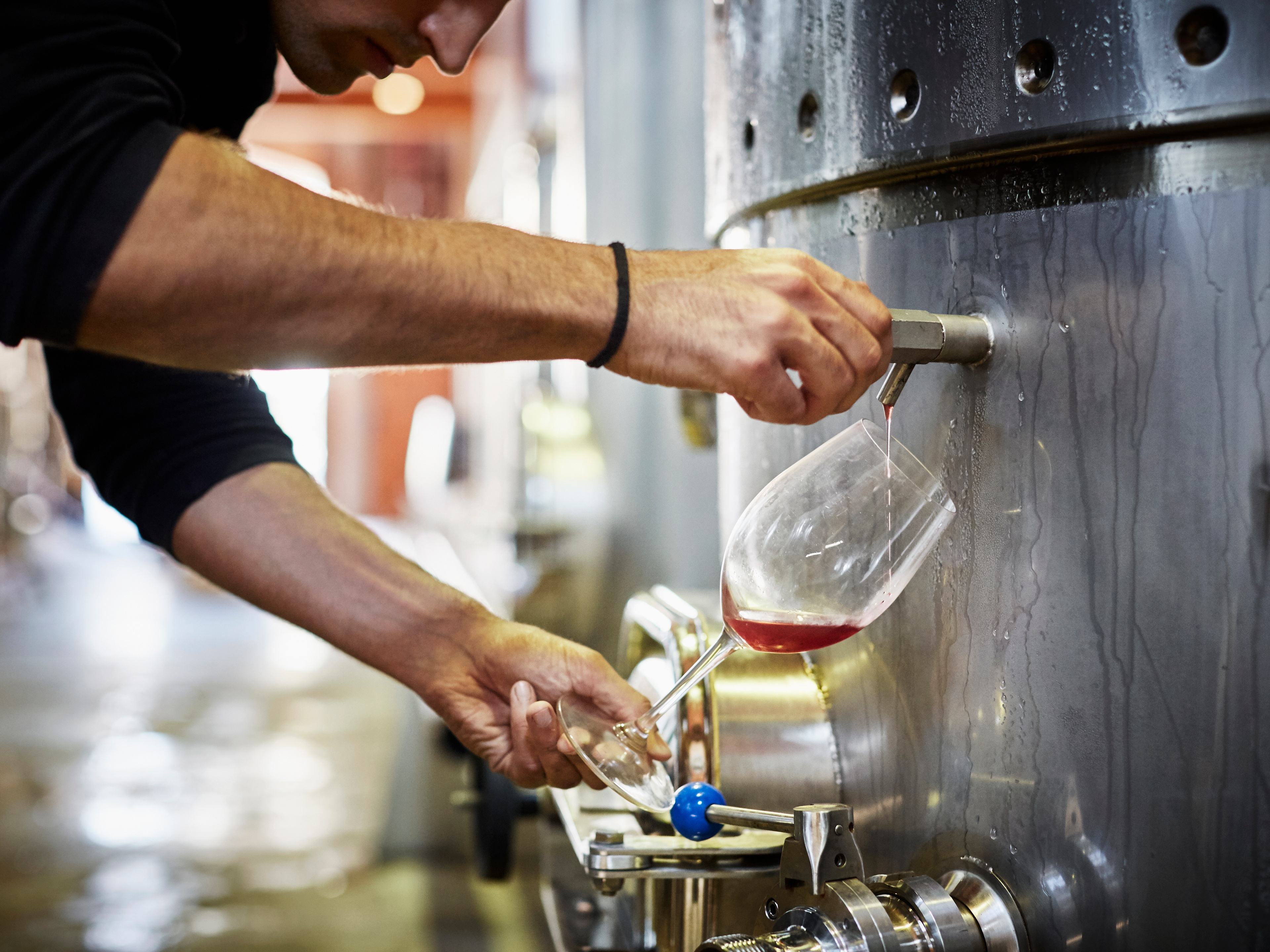 A man filling up a glass of wine