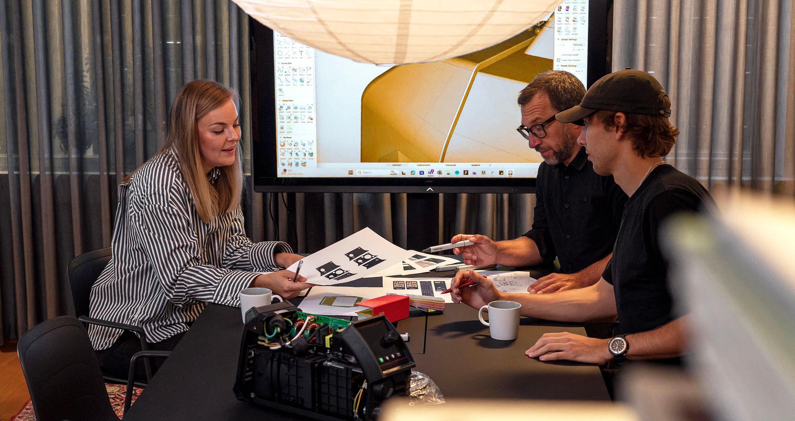 Two people collaborating at a table with design material 
