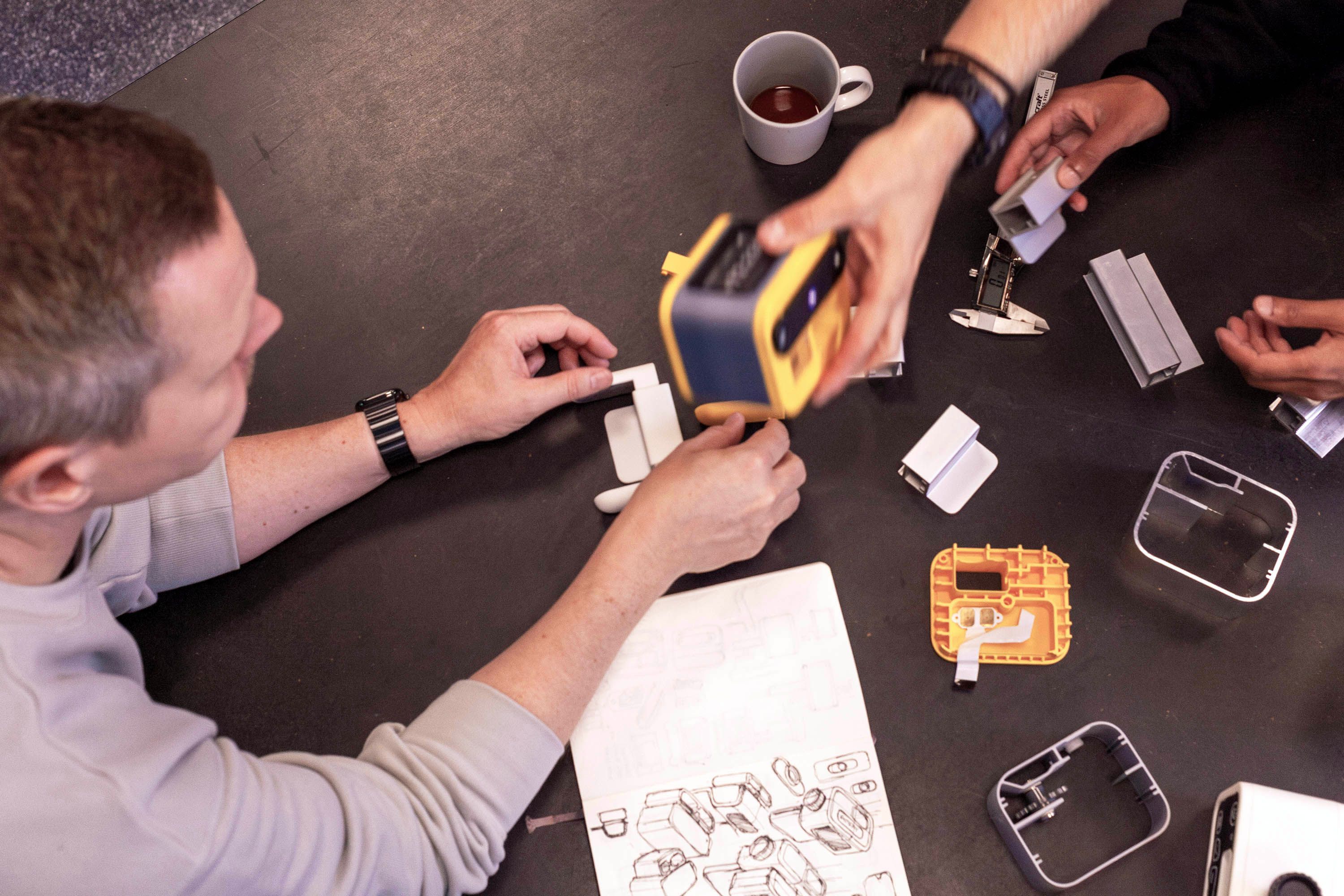 People collaborating at a table with prototypes