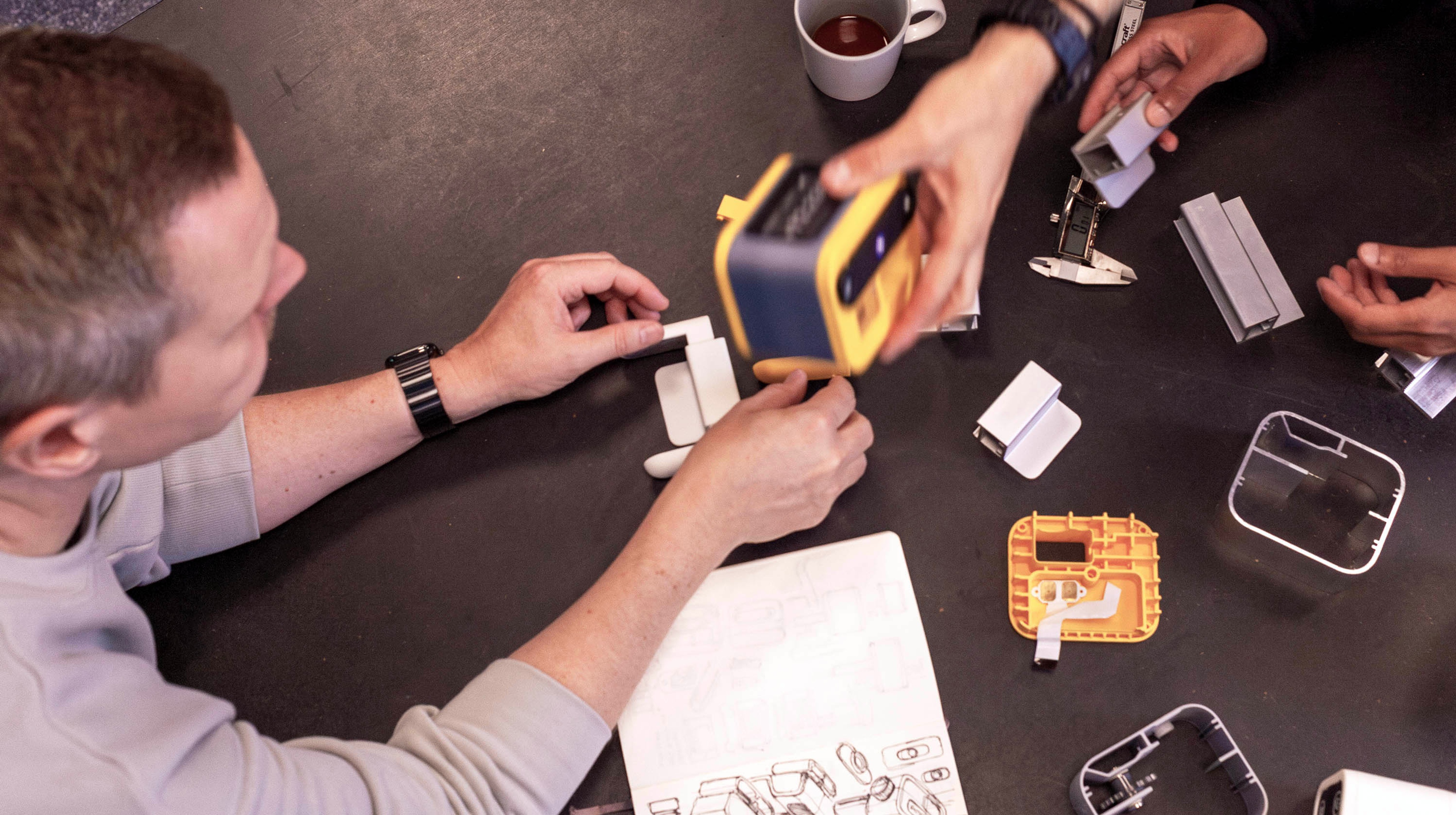 People at a workstation looking at prototypes