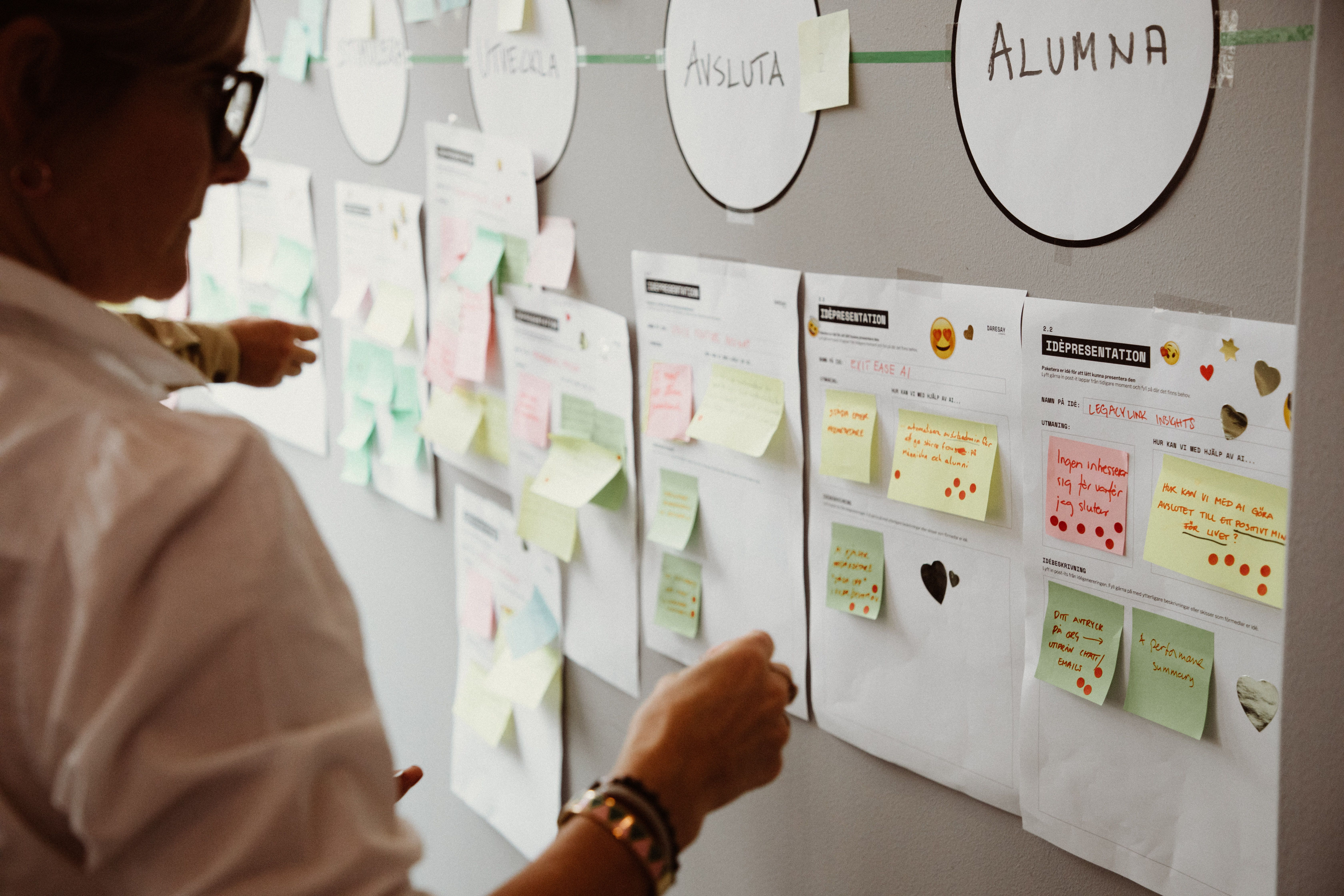 Person looking at a bulletin board filled with notes