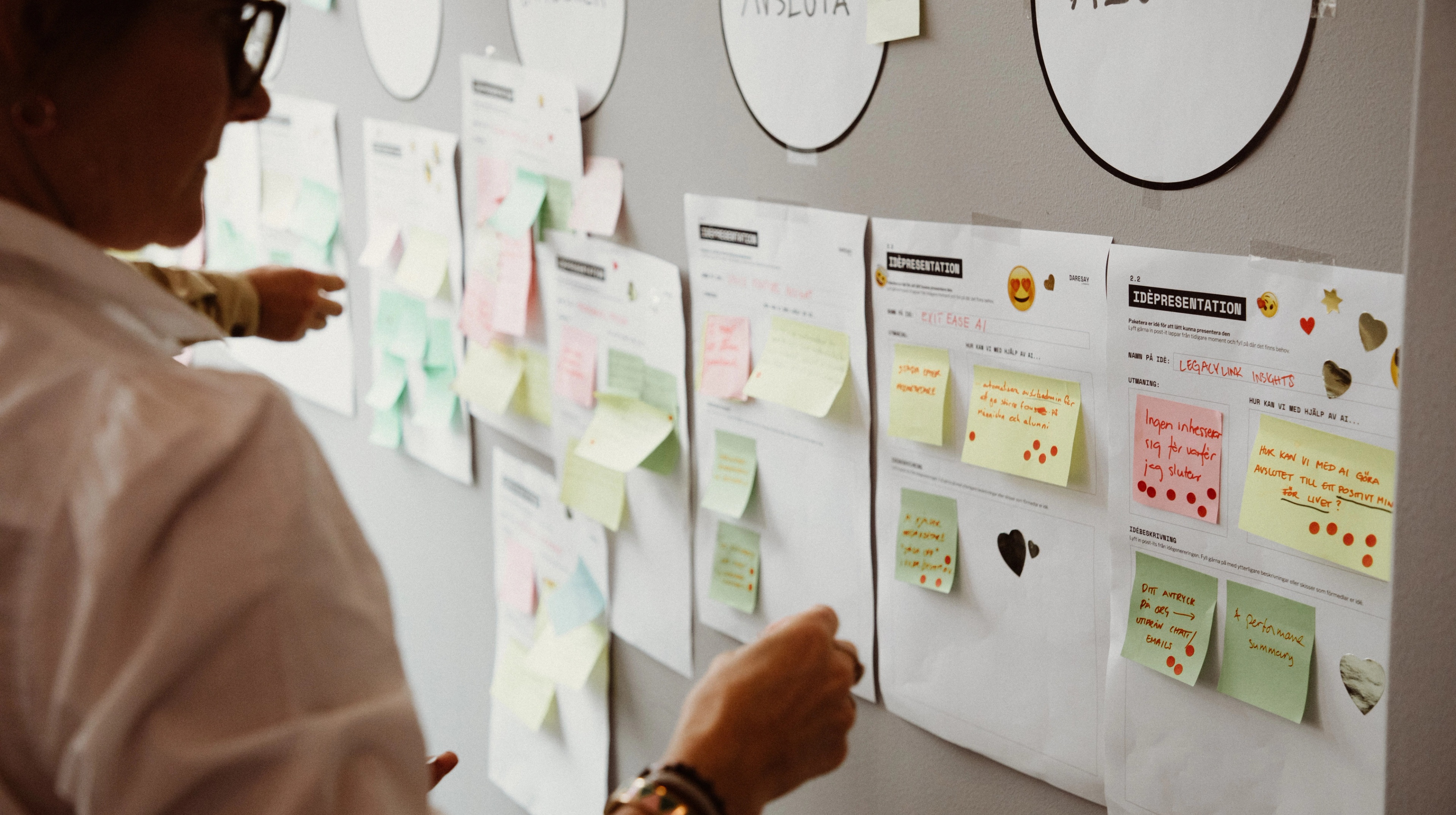 Person looking at a bulletin board filled with notes