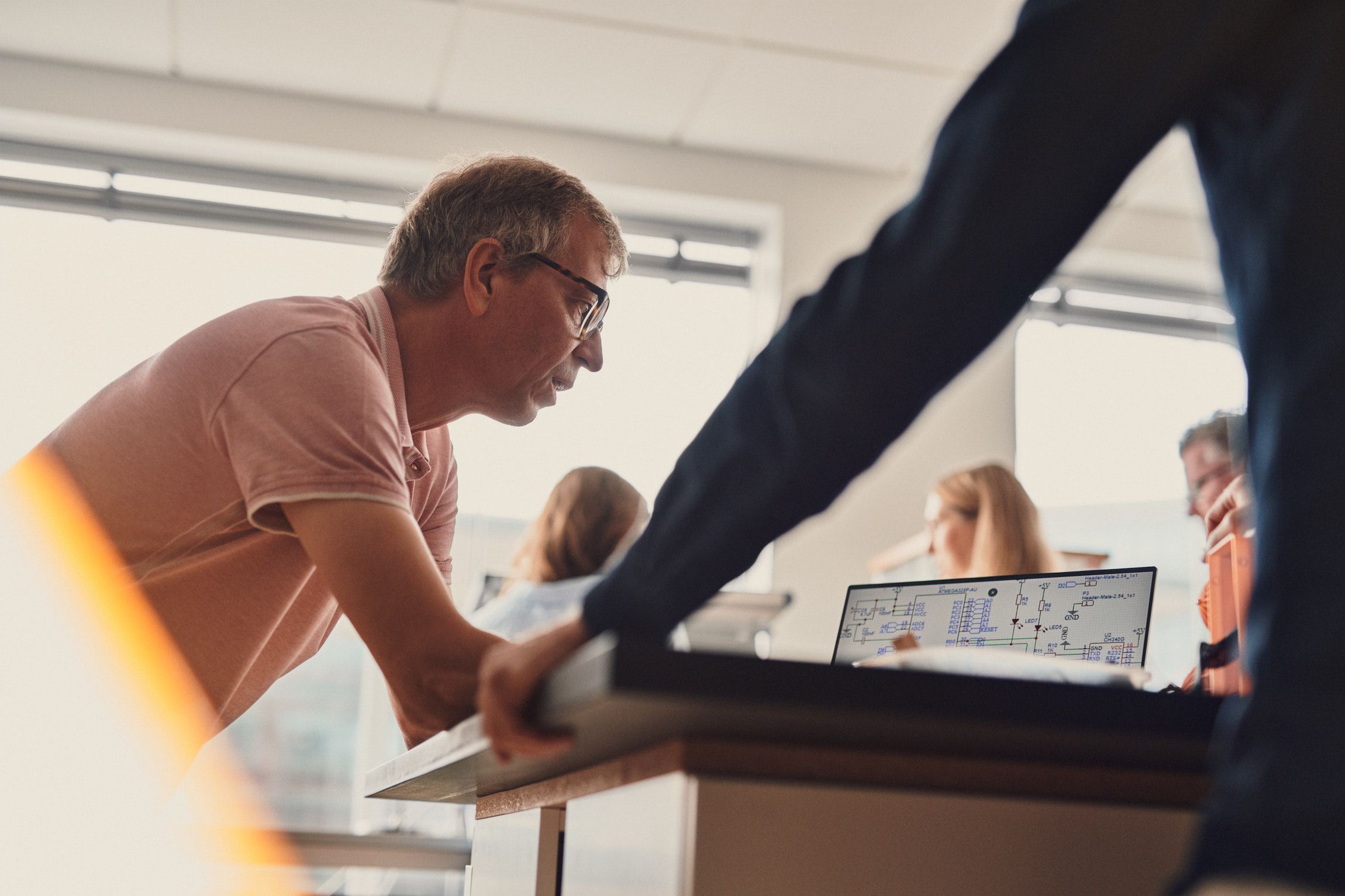 People talking at a table with a computer