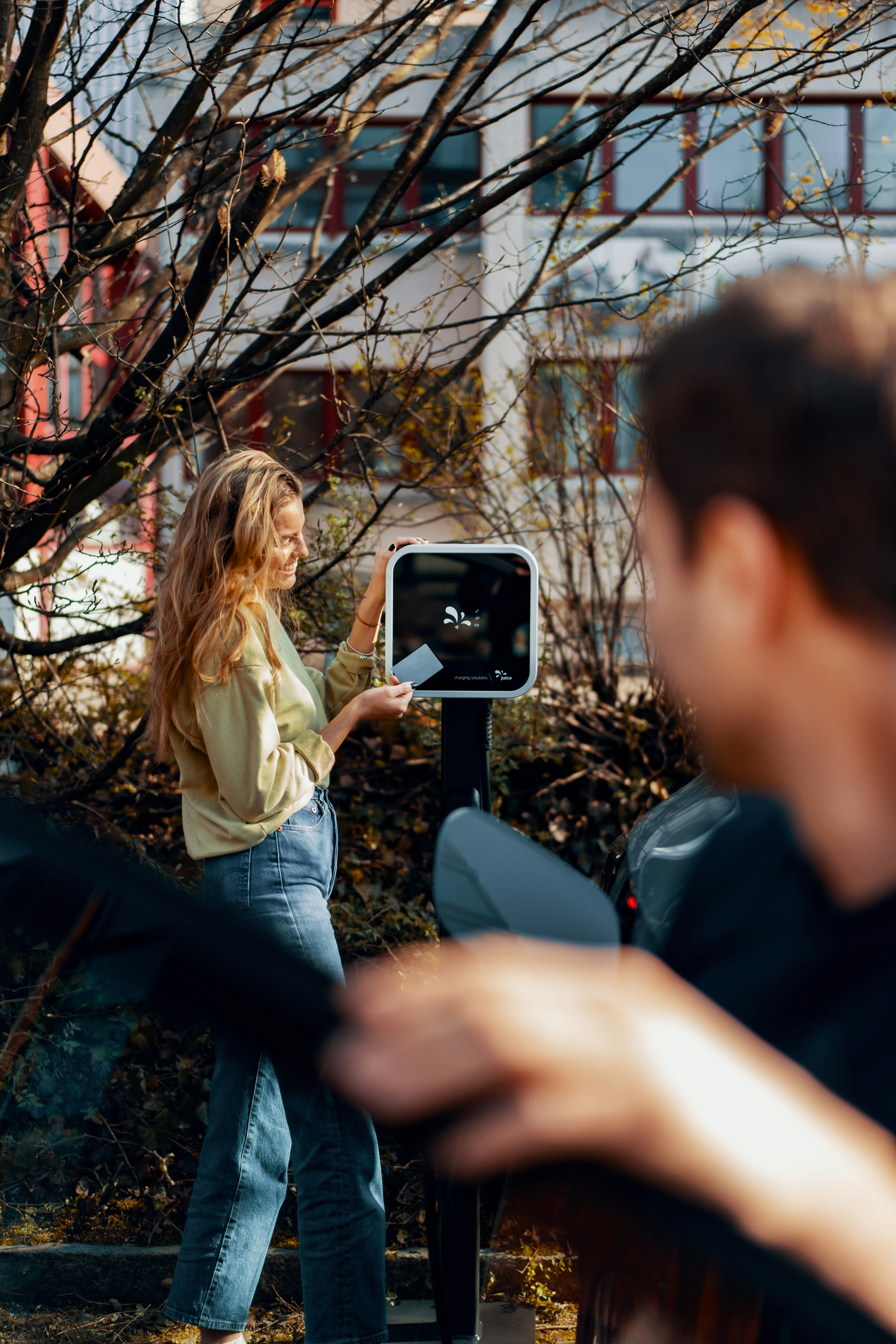 A woman paying for EV-charging.