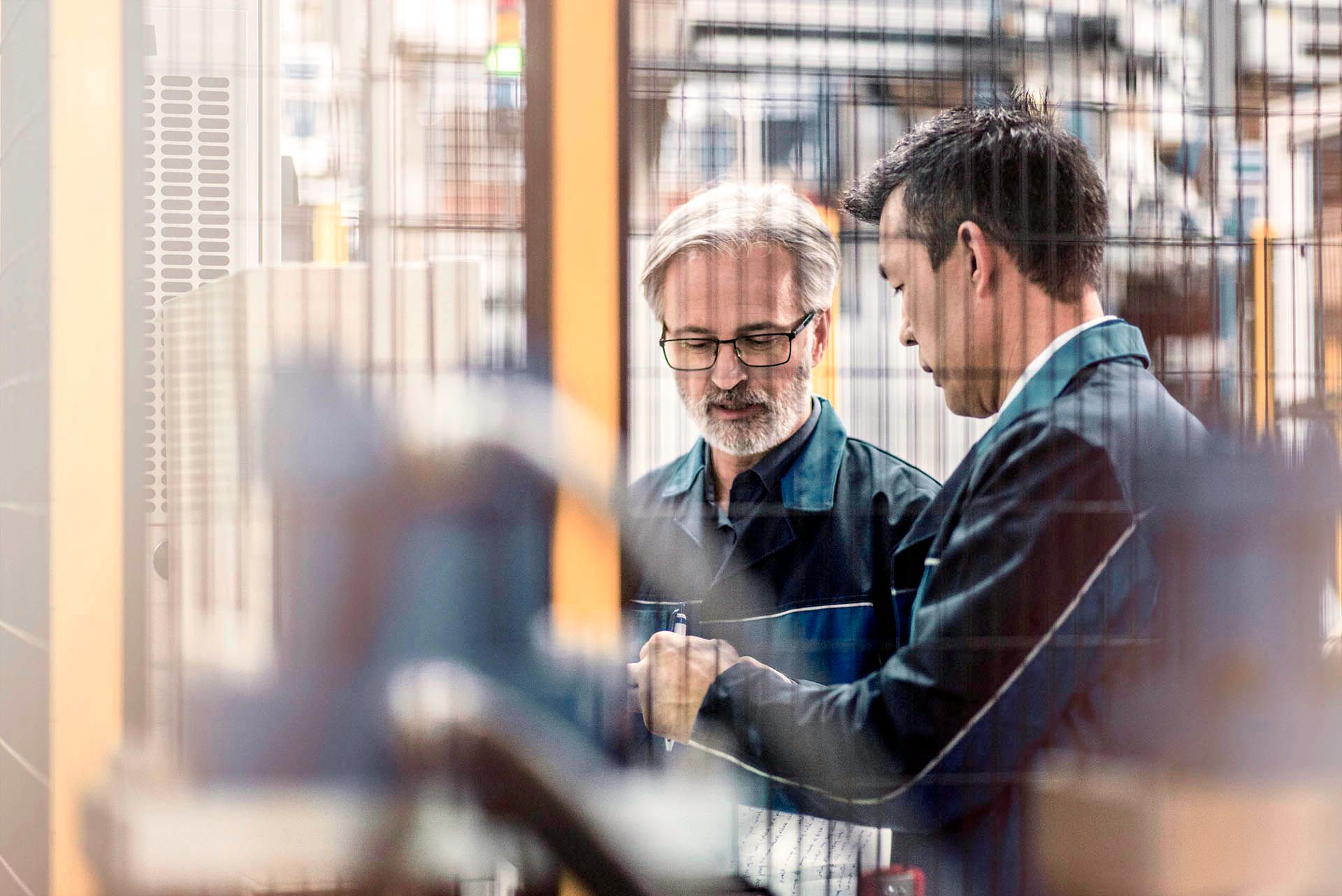 Two men talking in an industrial factory