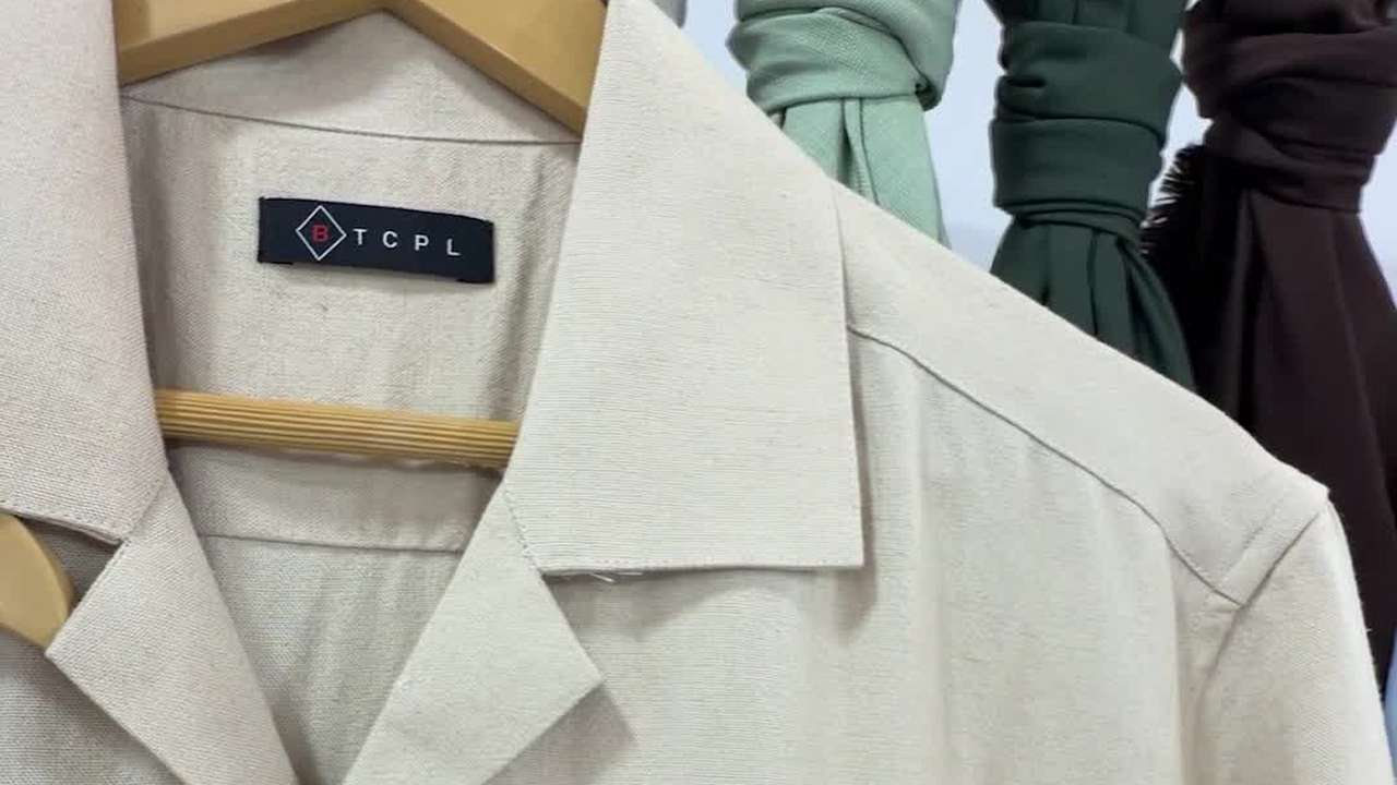 The fabric-details tag on a BTCPL sample shirt, listing design number, count, construction, blend, weave, width, GSM and finish