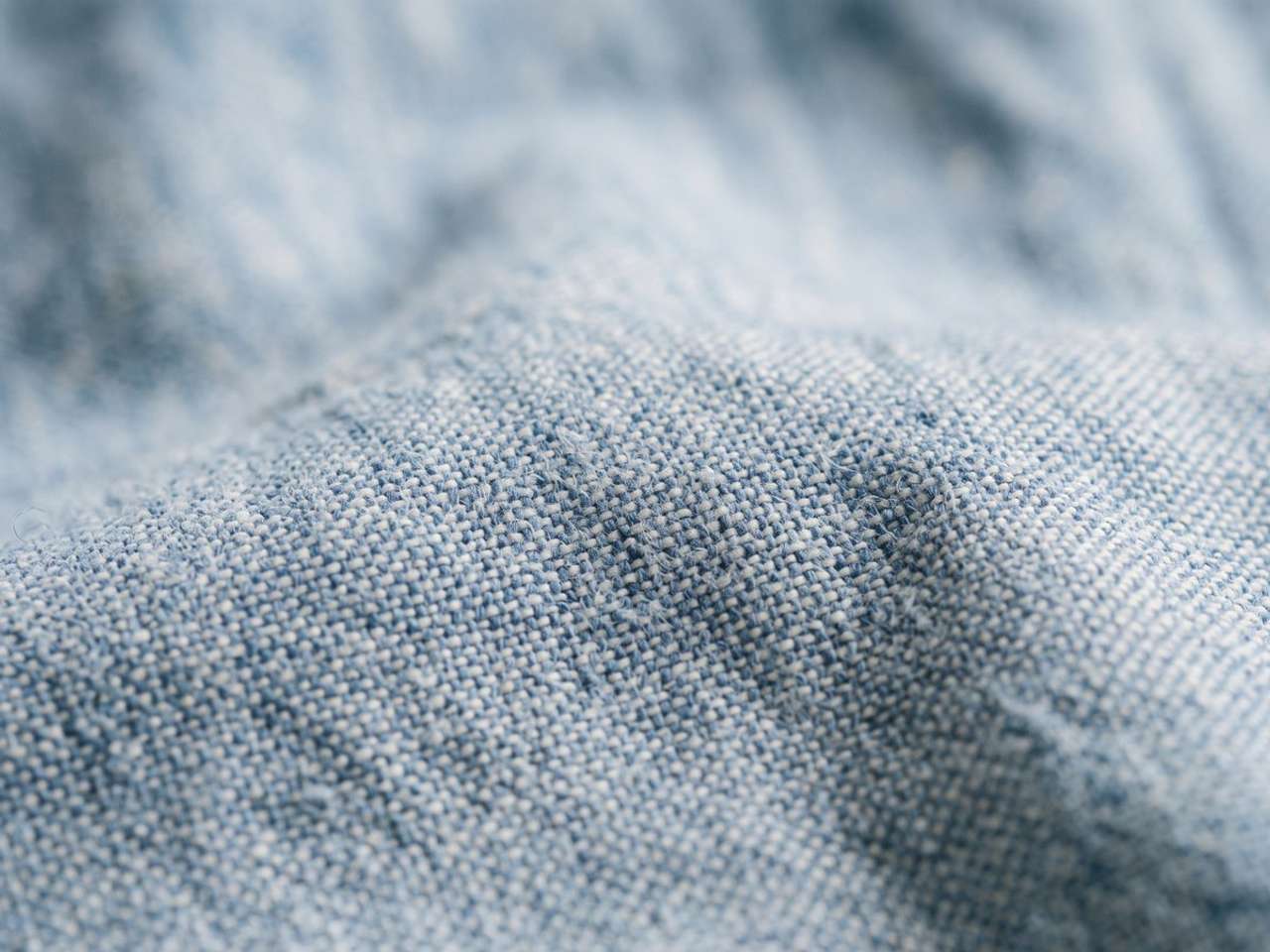 Close-up of chambray fabric showing coloured warp and white weft threads