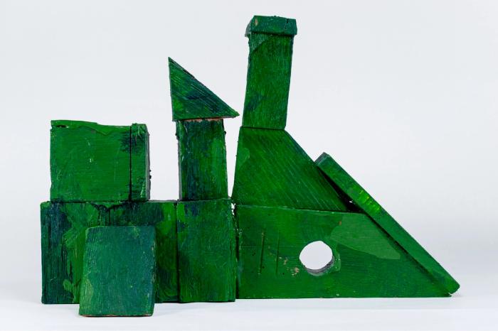 Green painted wooden sculpture on a white background