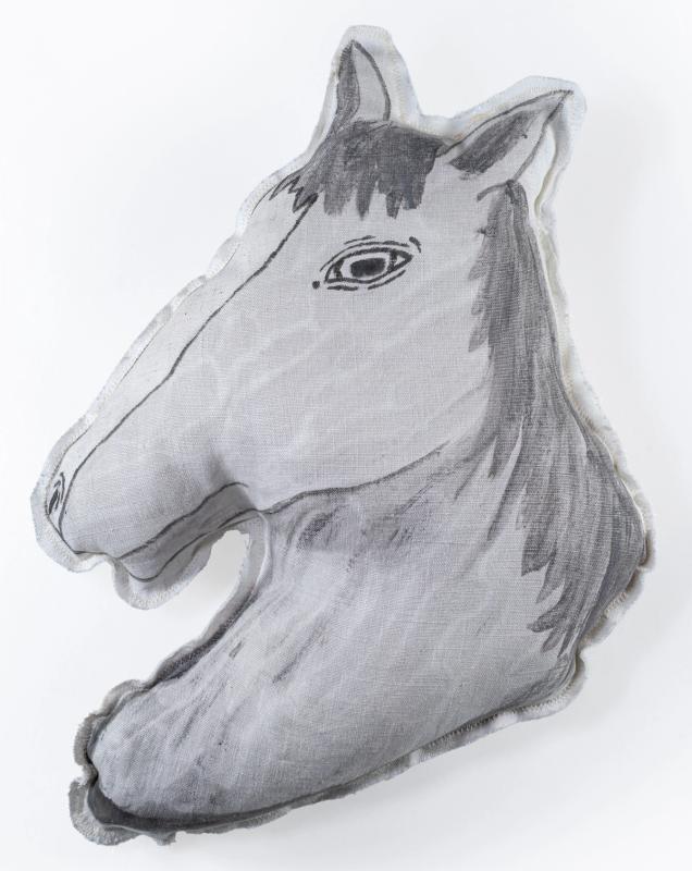 a pillow in the shape of a horse. its mostly light gray, with the features conveyed by dark lines. its in profile and has long hair.