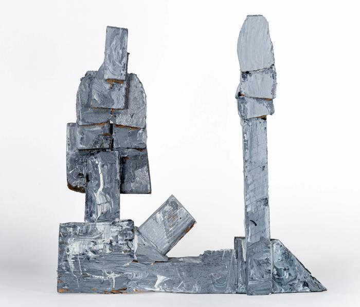 Abstract sculpture made of wood, glue, and heavy chrome and white colored paint on a white background