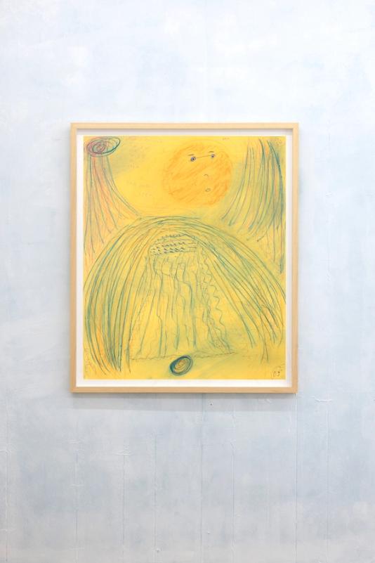 a cloudily painted pale blue and white wall with a framed artwork hanging in a light wooden frame. the artwork inside is a drawing on yellow paper thats mostly blue lines. Its hazy and theres a large figure in the center with a red circular shaped head. the figure has wings or arms stretched up to the top of the page.