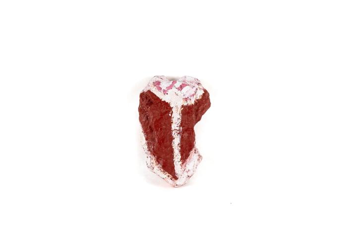 a sculpture in the shape of a very red steak. its surface is very textured and the painting is dark red and bright white. 