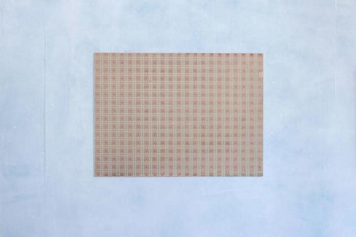 a rectangular painting with a mostly stark pink and greenish grid that appears like a textile. its mounted to the wall with no depth.
