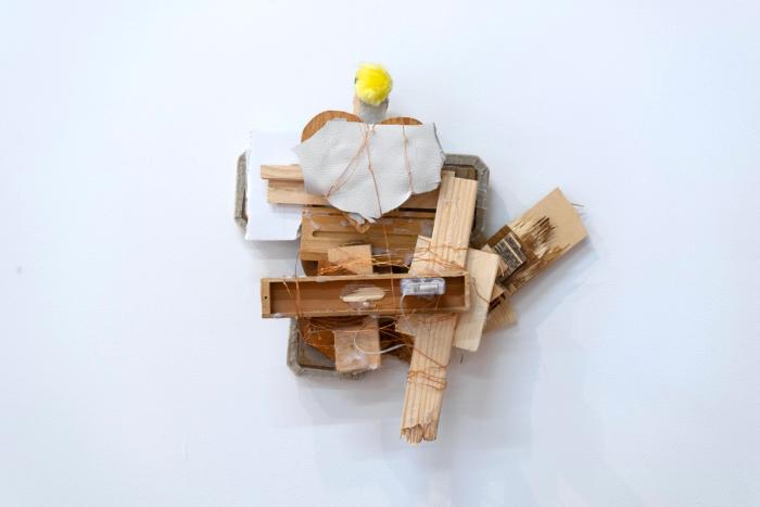 An abstract mixed media sculpture created with wood, glue, wire, and other materials.