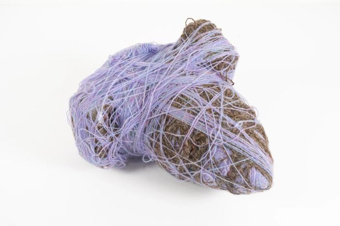 A mixed media, abstract sculpture made of wool yarn, polyester thread, cardboard, masking tape, polyfill, wood, and saran wrap.