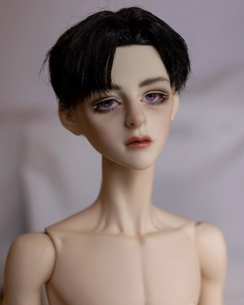 Portrait photo of a male ball-jointed doll with short black hair with 90s-style bangs, thick spidery lashes and a very amateurish faceup.