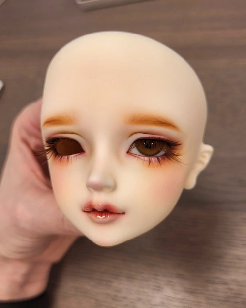 Female ball-jointed doll head with one brown glass eye inserted.