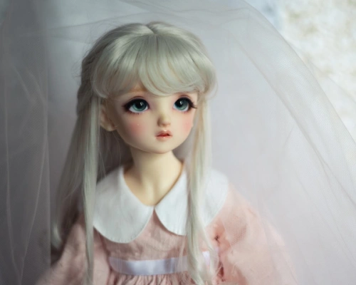 Portrait of a female ball-jointed doll in a light pink dress with a large white collar and a white ribbon belt. She has long silvery-white hair pulled back into a half-up style with a fringe, and a rather worried expression.