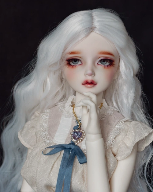 Female ball-jointed doll with long wavy white hair, blue eyes, wearing a cream lacy blouse and a gold amethyst necklace.