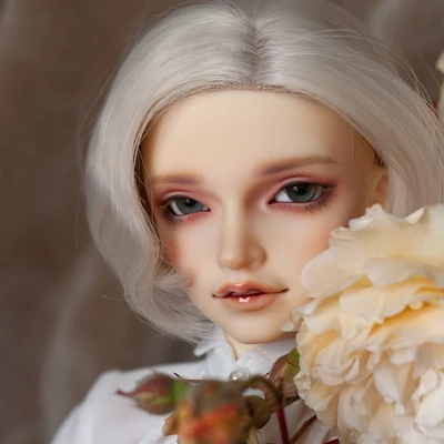 Male resin ball-jointed doll with chin-length white hair, wearing a white dress shirt, next to peach roses and rosebuds.