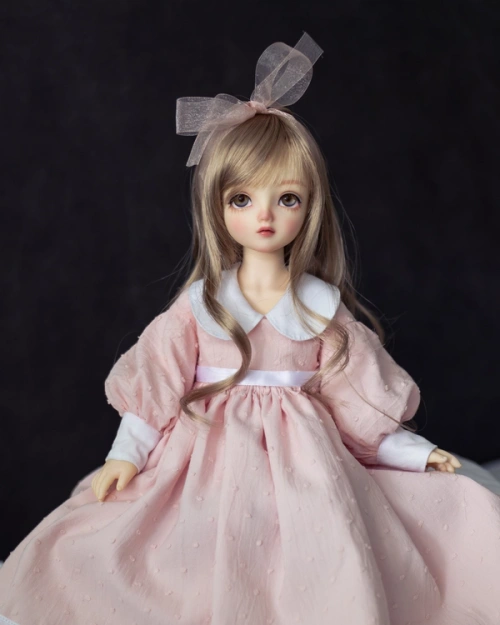 Female ball-jointed doll wearing a light pink full-skirted dress with puffy sleeves and a wide white collar.