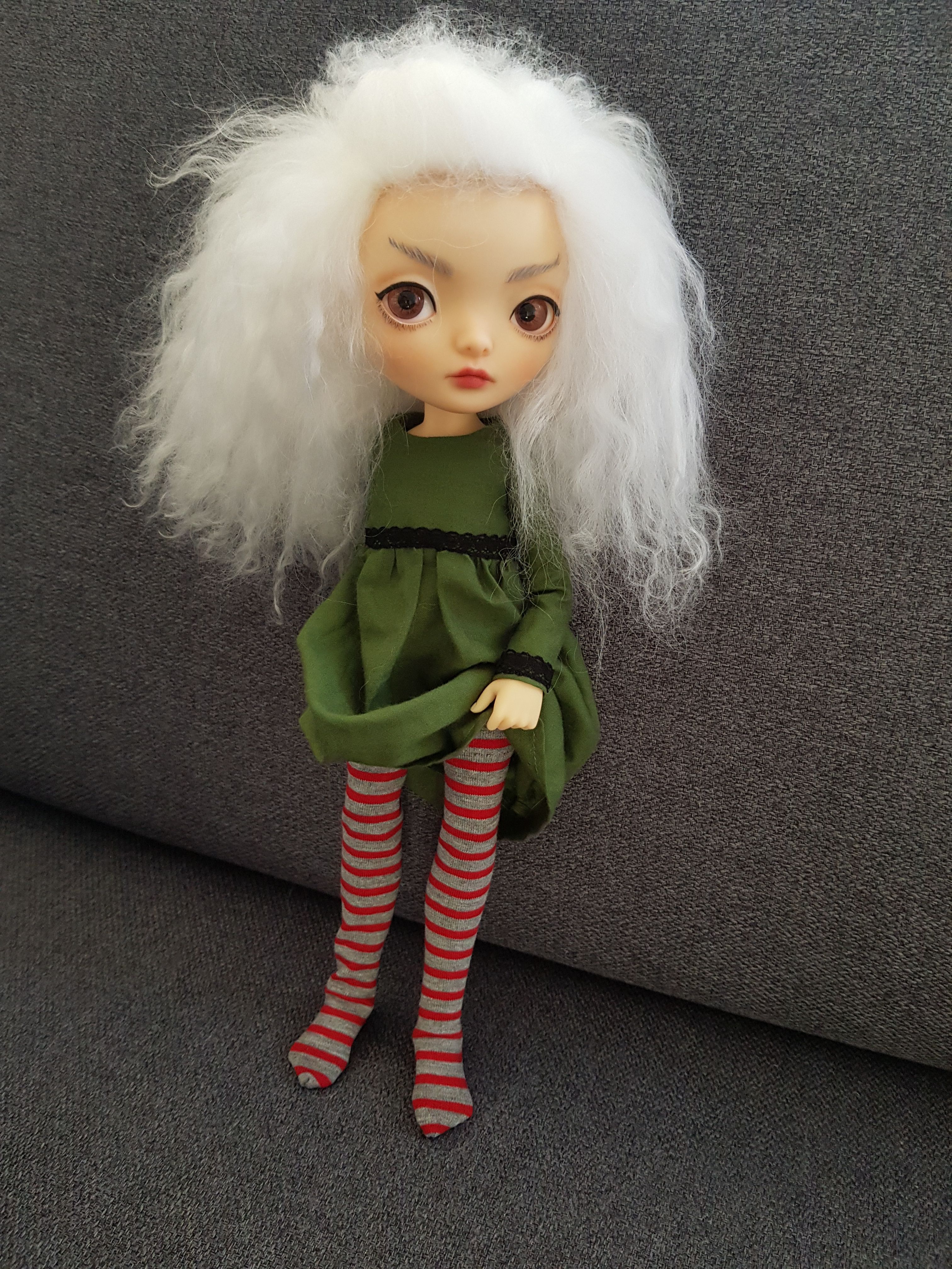 Female ball-jointed resin doll with a cloud of fluffy white hair, big eyes, and an elfin expression.