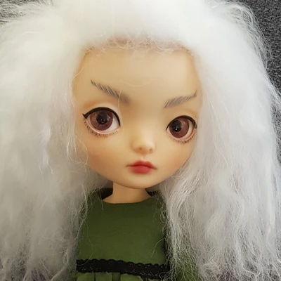 Female ball-jointed resin doll with a cloud of fluffy white hair, big eyes, and an elfin expression.