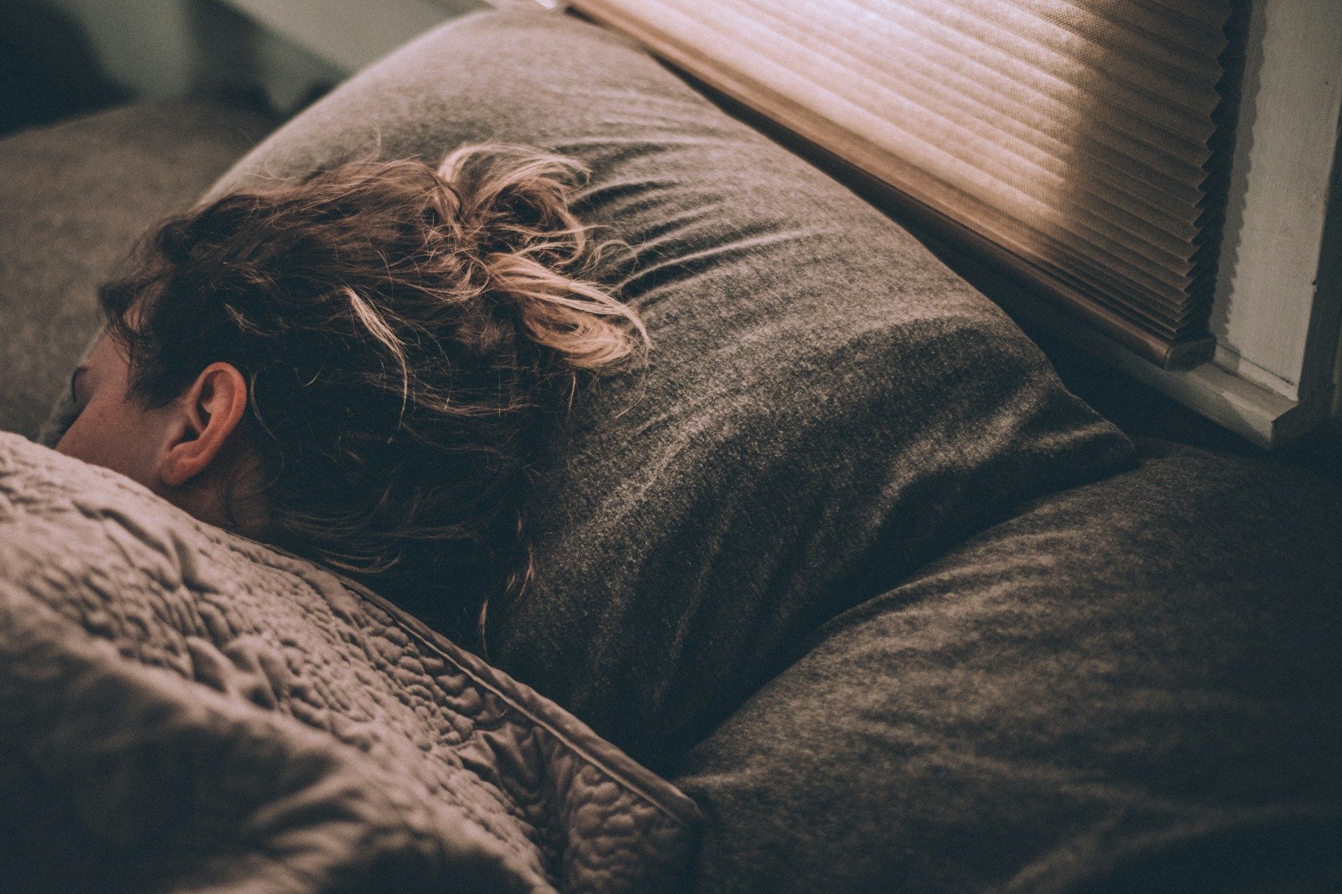 Woman sleeping on bed under blankets photo