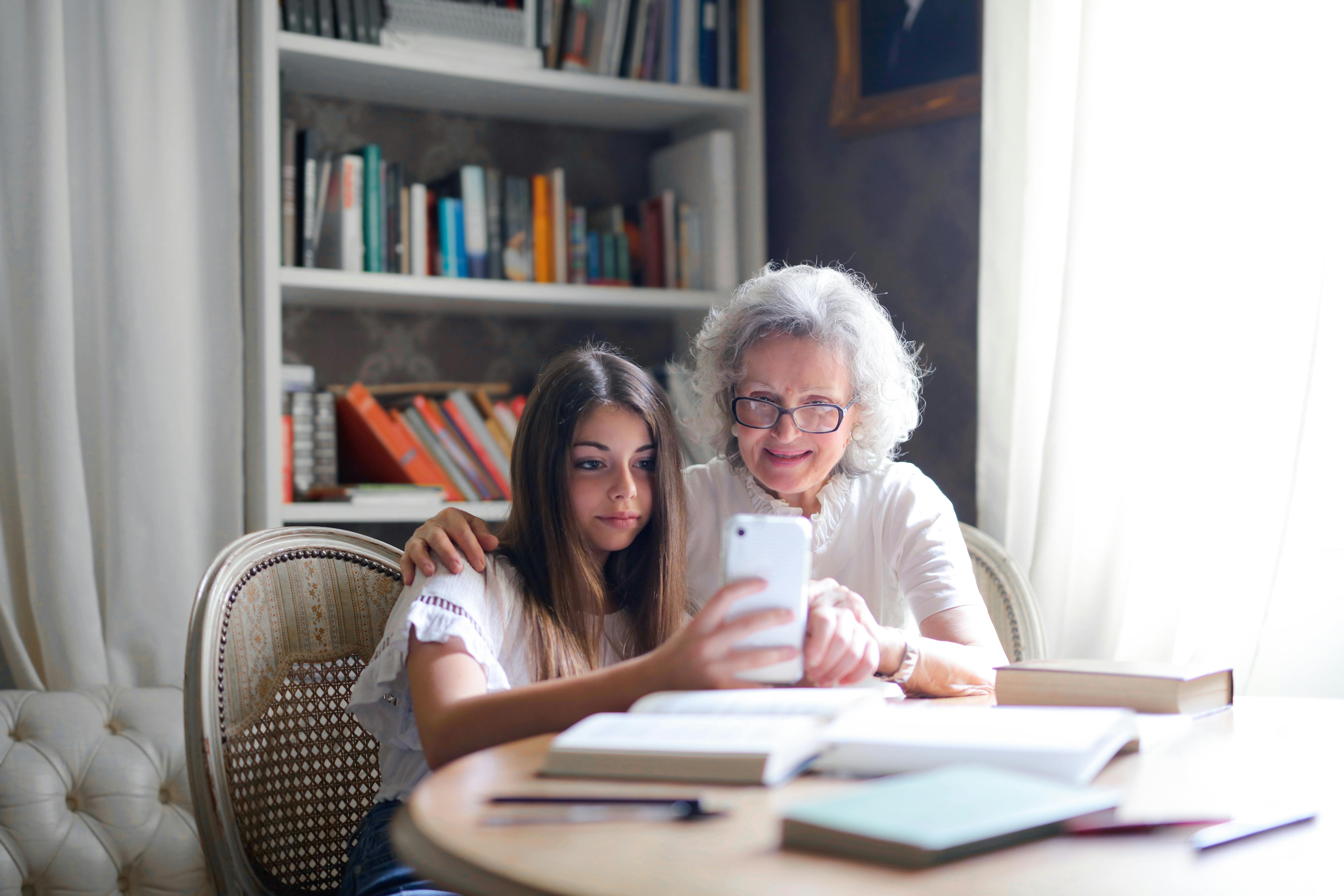 teenager showing grandma how to use an app