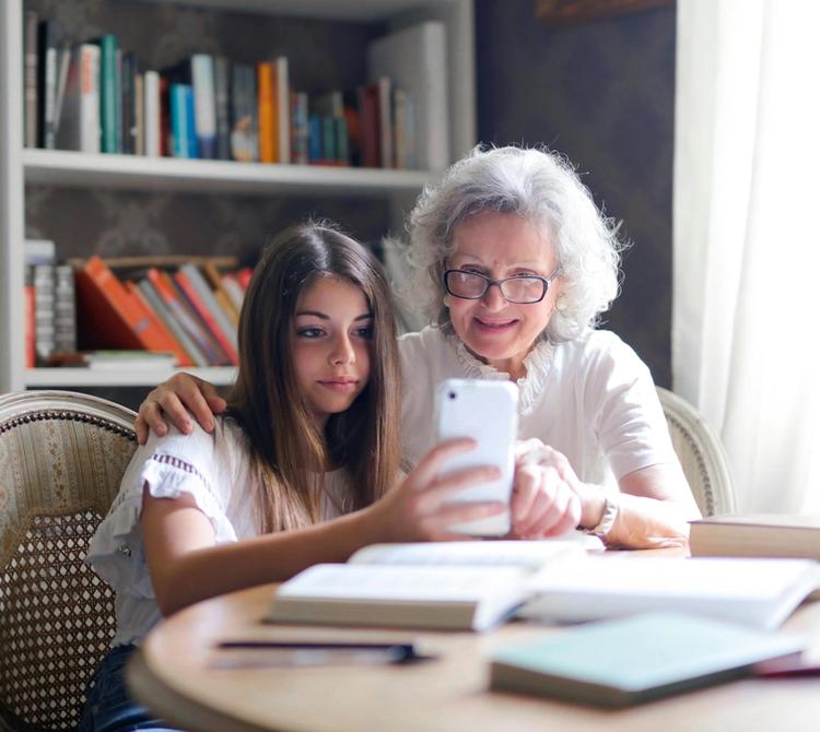 teenager showing grandma how to use an app