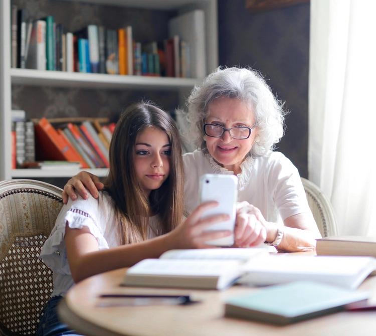 teenager showing grandma how to use an app teenager showing grandma how to use an app